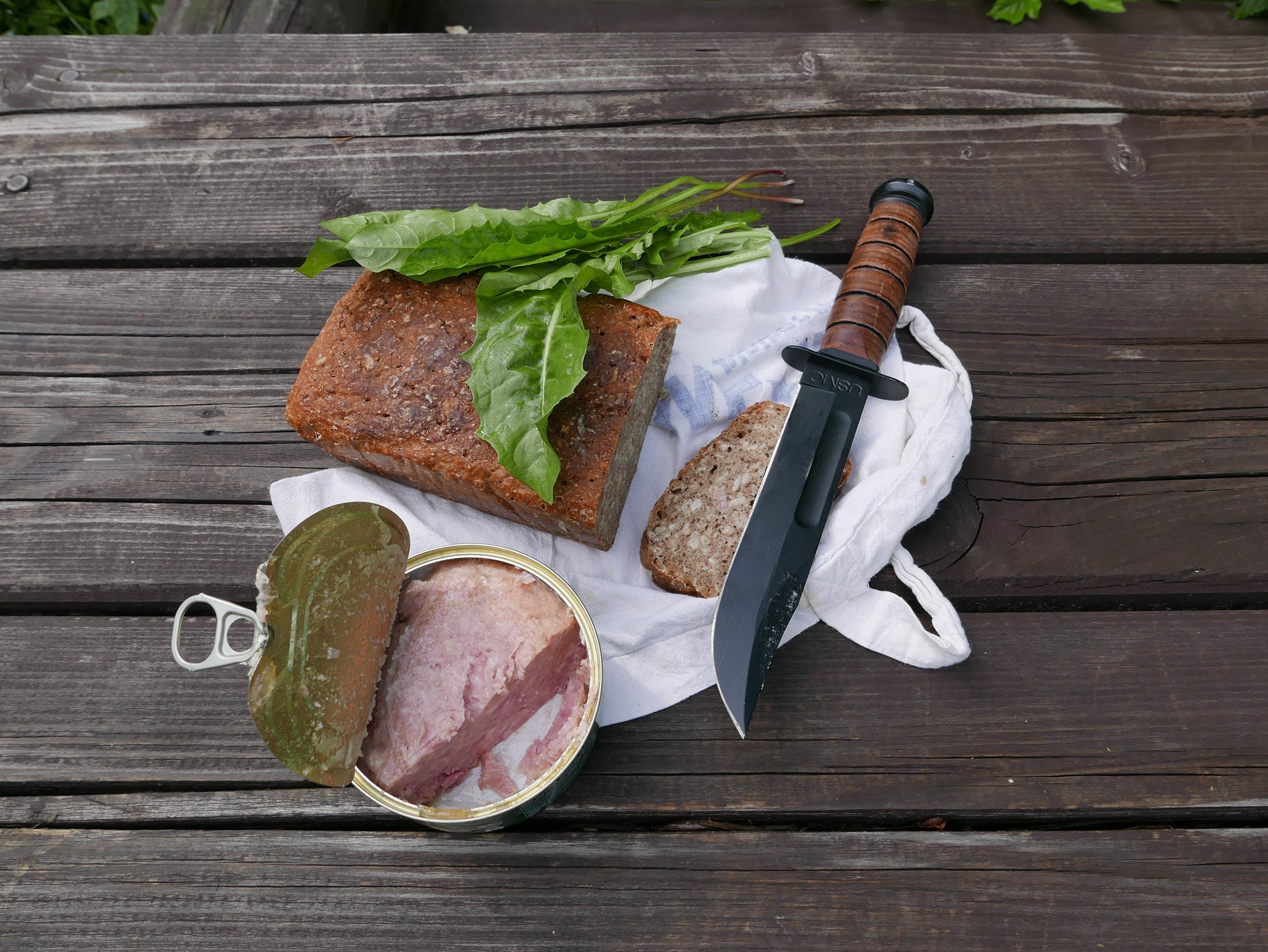 Canned food, bread, and knife on a wooden table HD Wallpaper