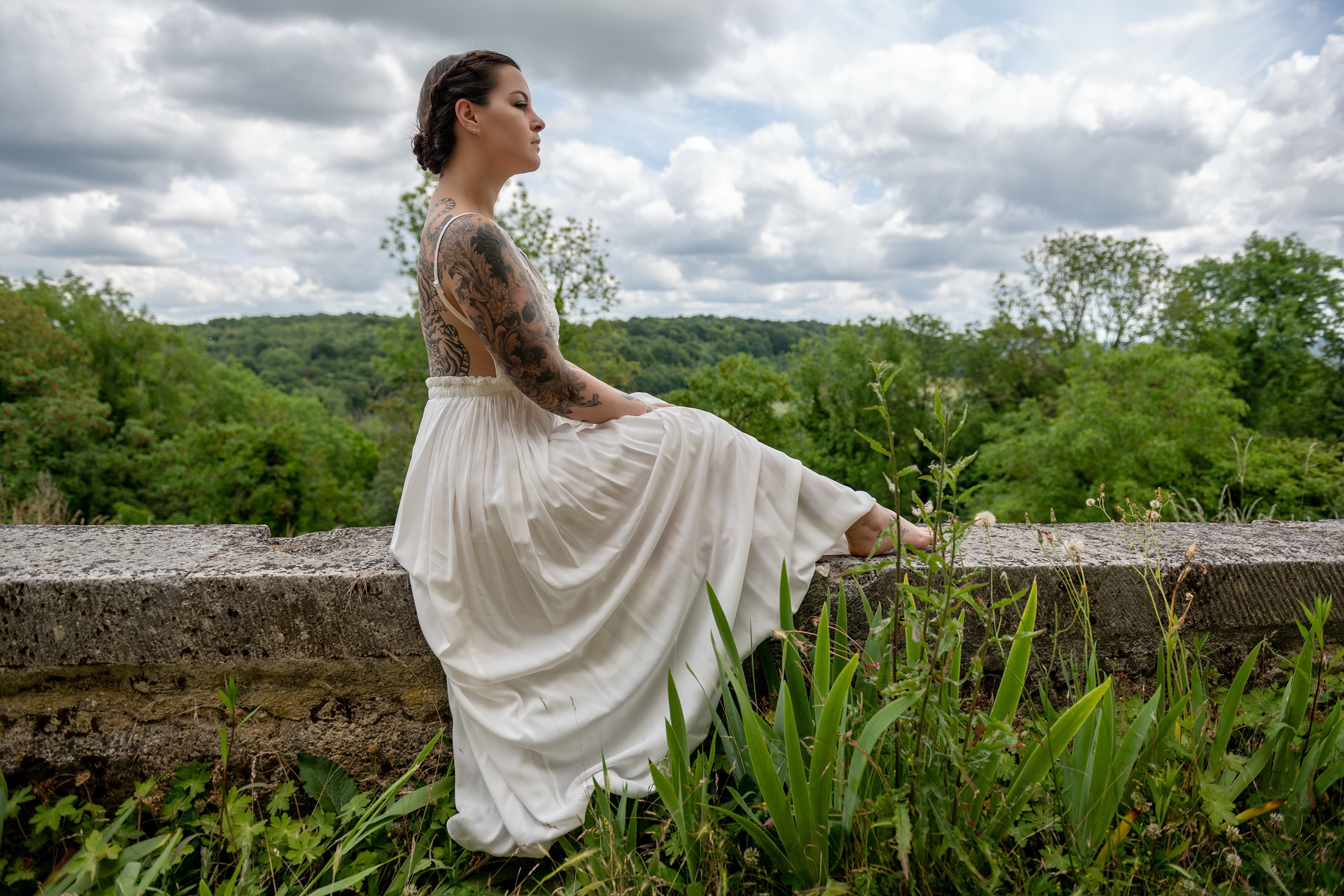 Woman with tattoos sitting on a wall HD Wallpaper