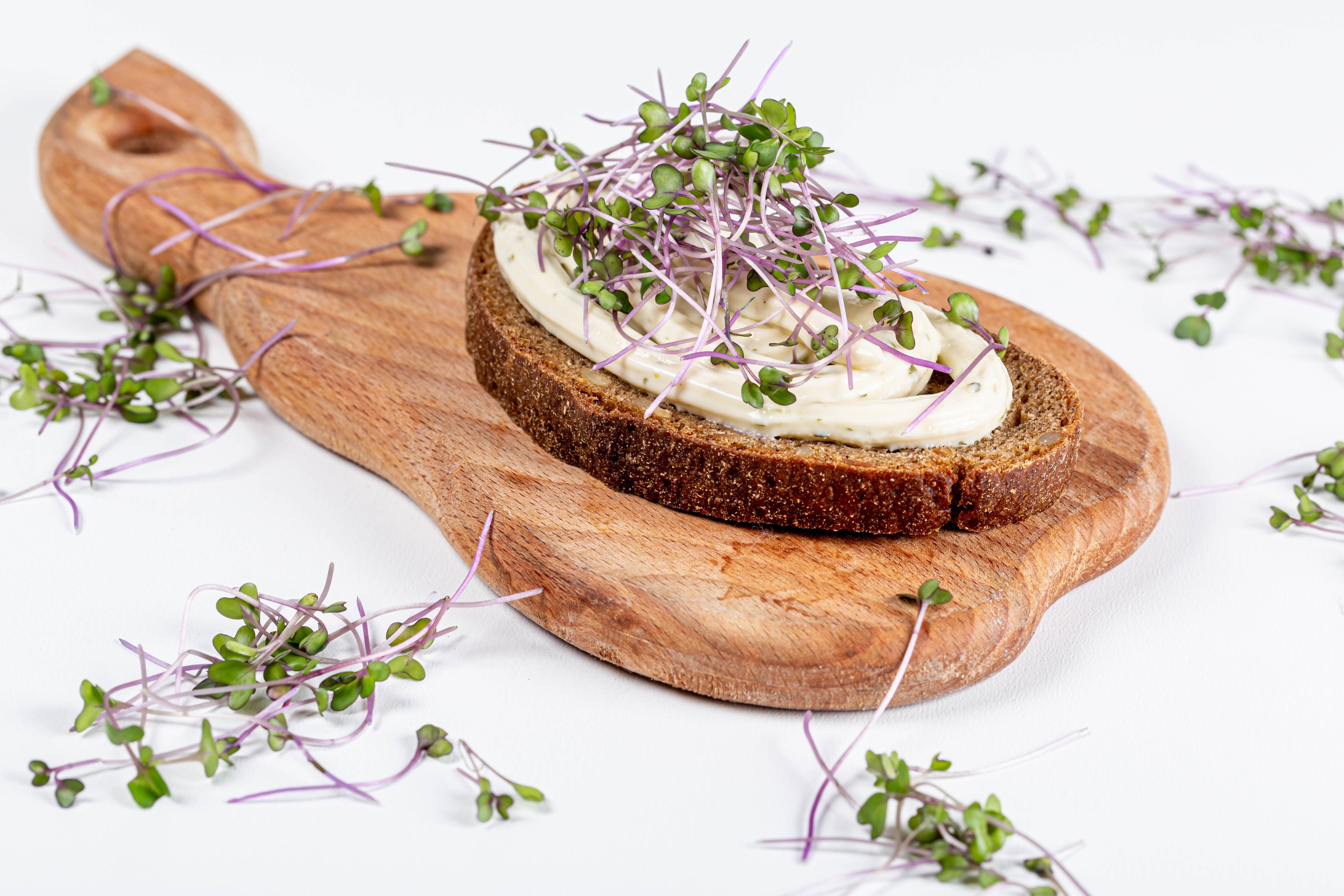 Bread with cream and sprouts on cutting board HD Wallpaper
