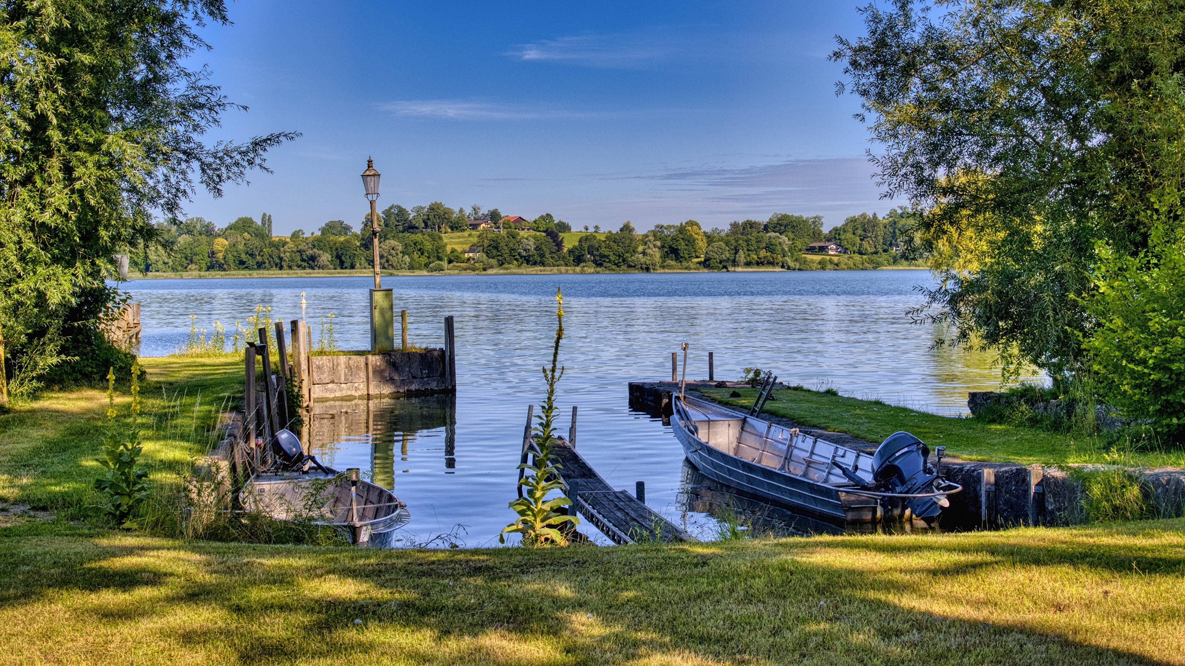 Boats docked at a lake with a lamp post in Bavaria, Germany HD Wallpaper