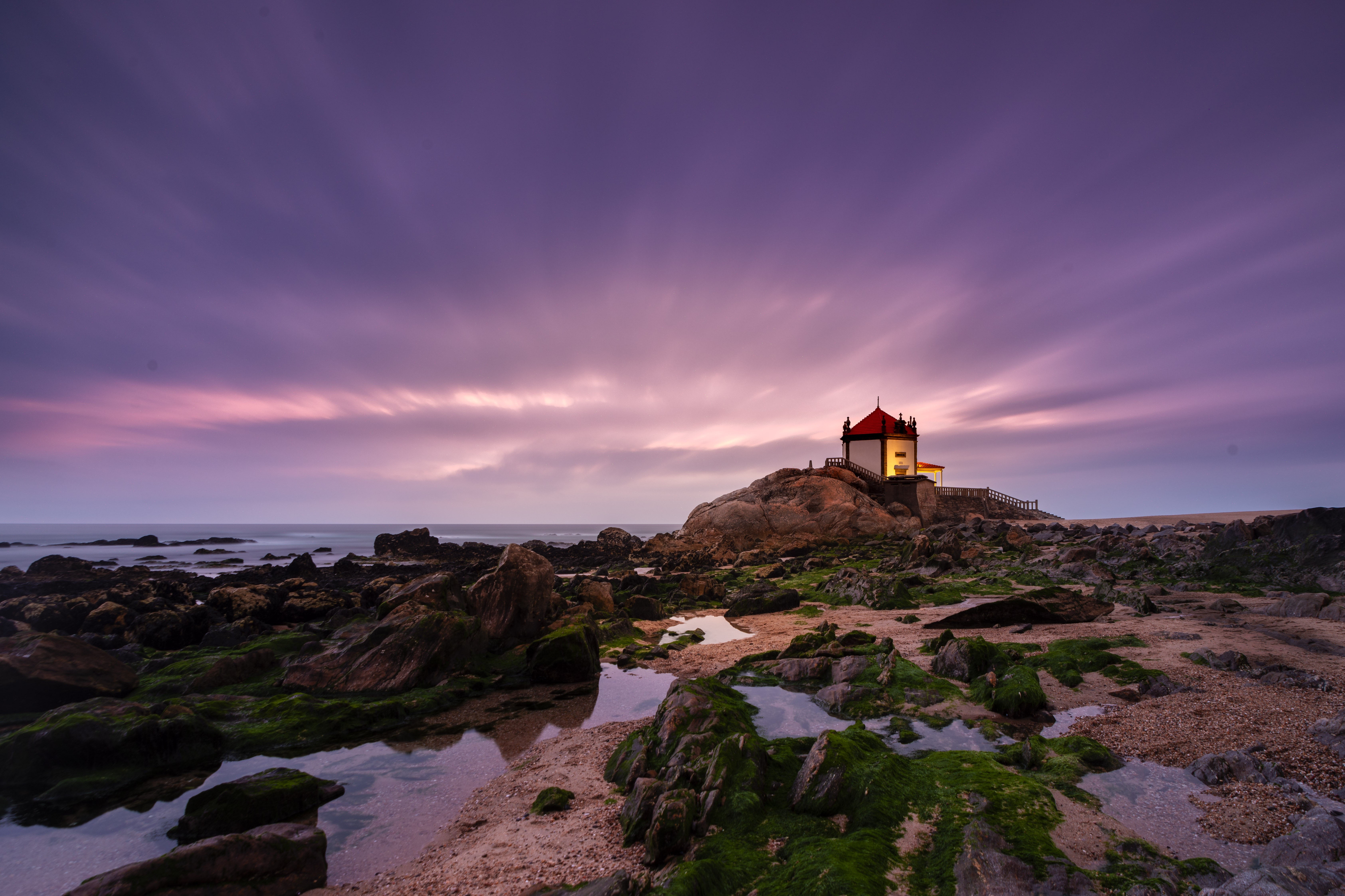 Capela do Senhor da Pedra church on rocky coast at sunset HD Wallpaper