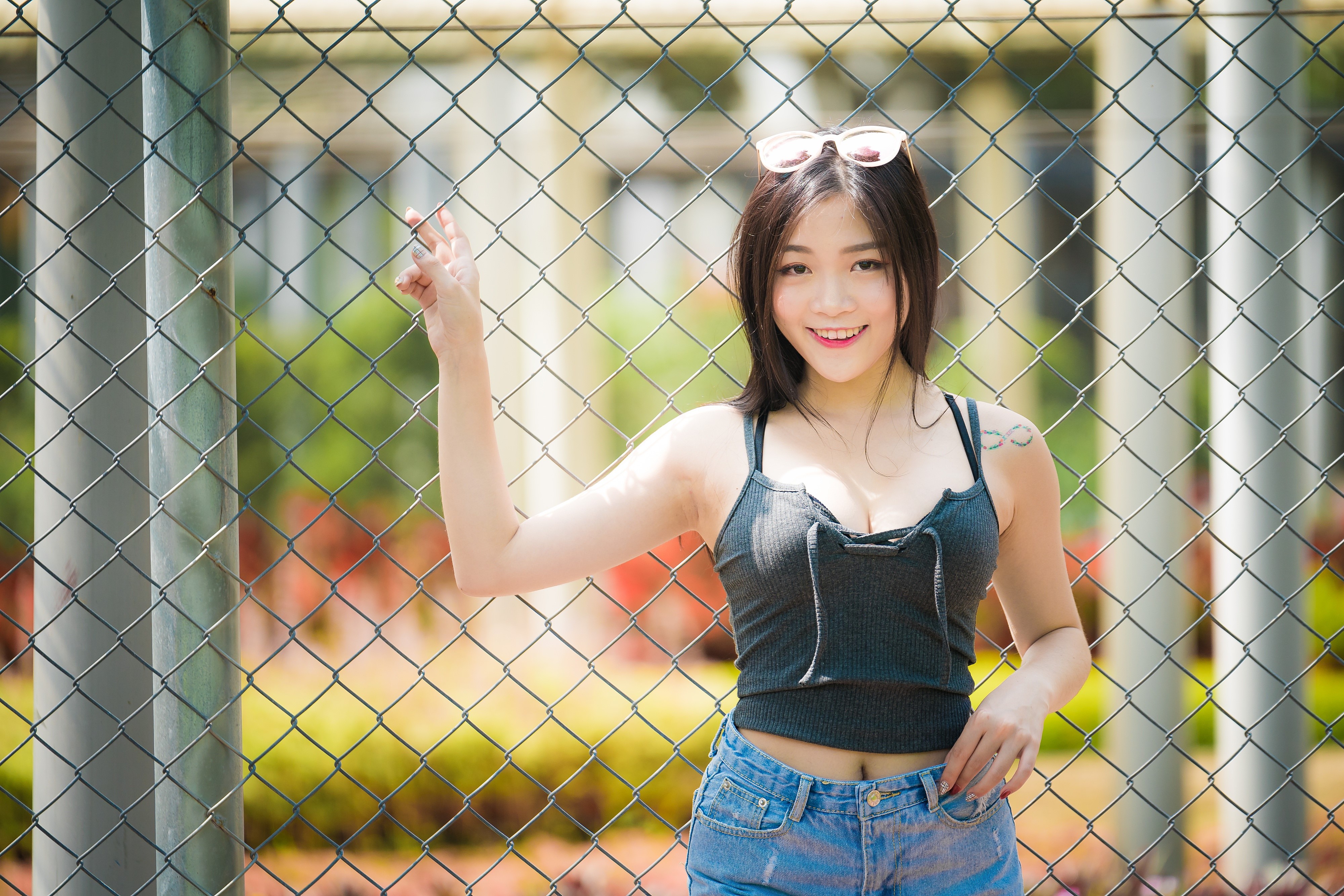 Brunette girl with glasses leaning on a fence HD Wallpaper