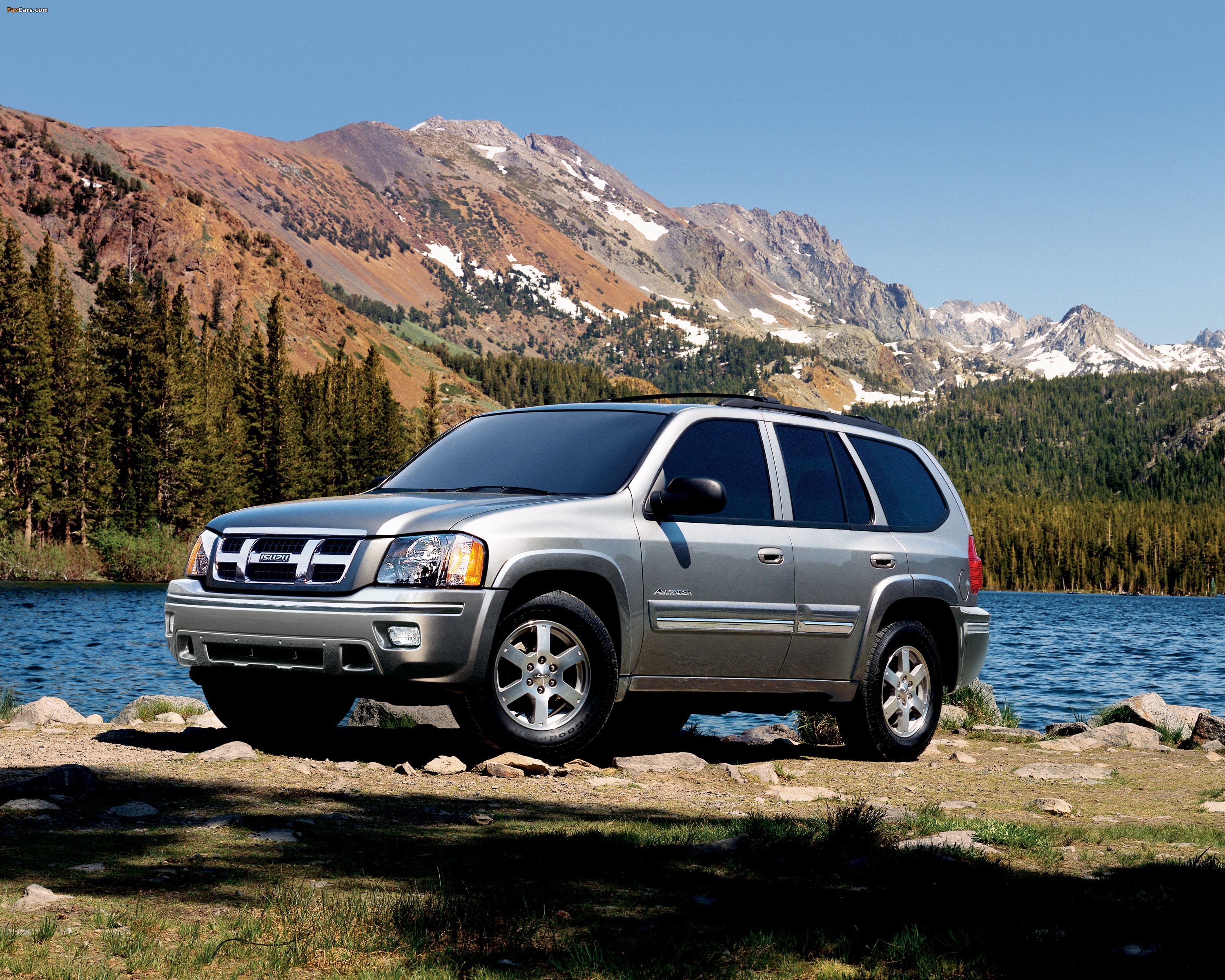 Silver Isuzu Ascender SUV parked by a lake with mountains HD Wallpaper