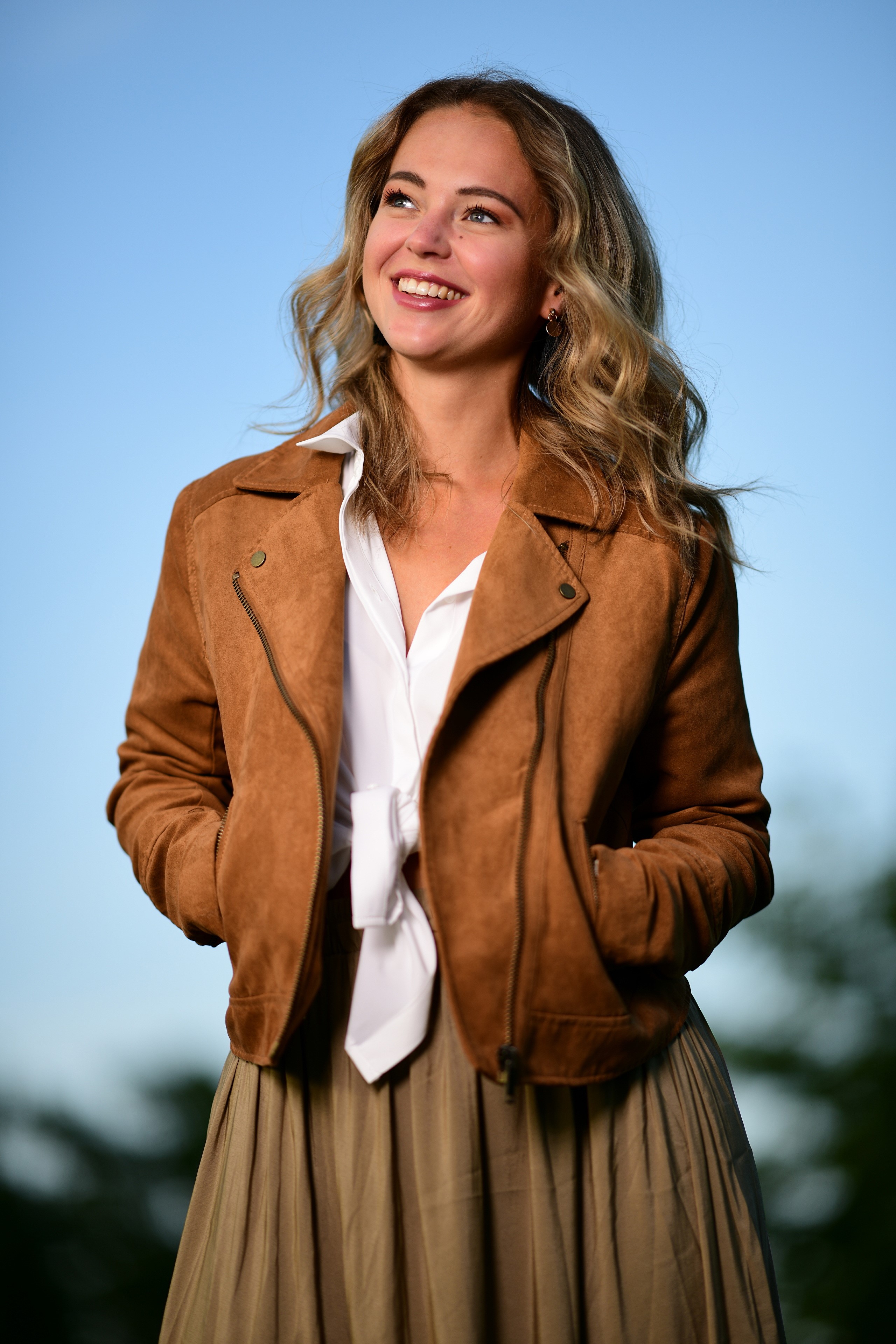 Selina wearing a brown jacket and white shirt HD Phone Wallpaper