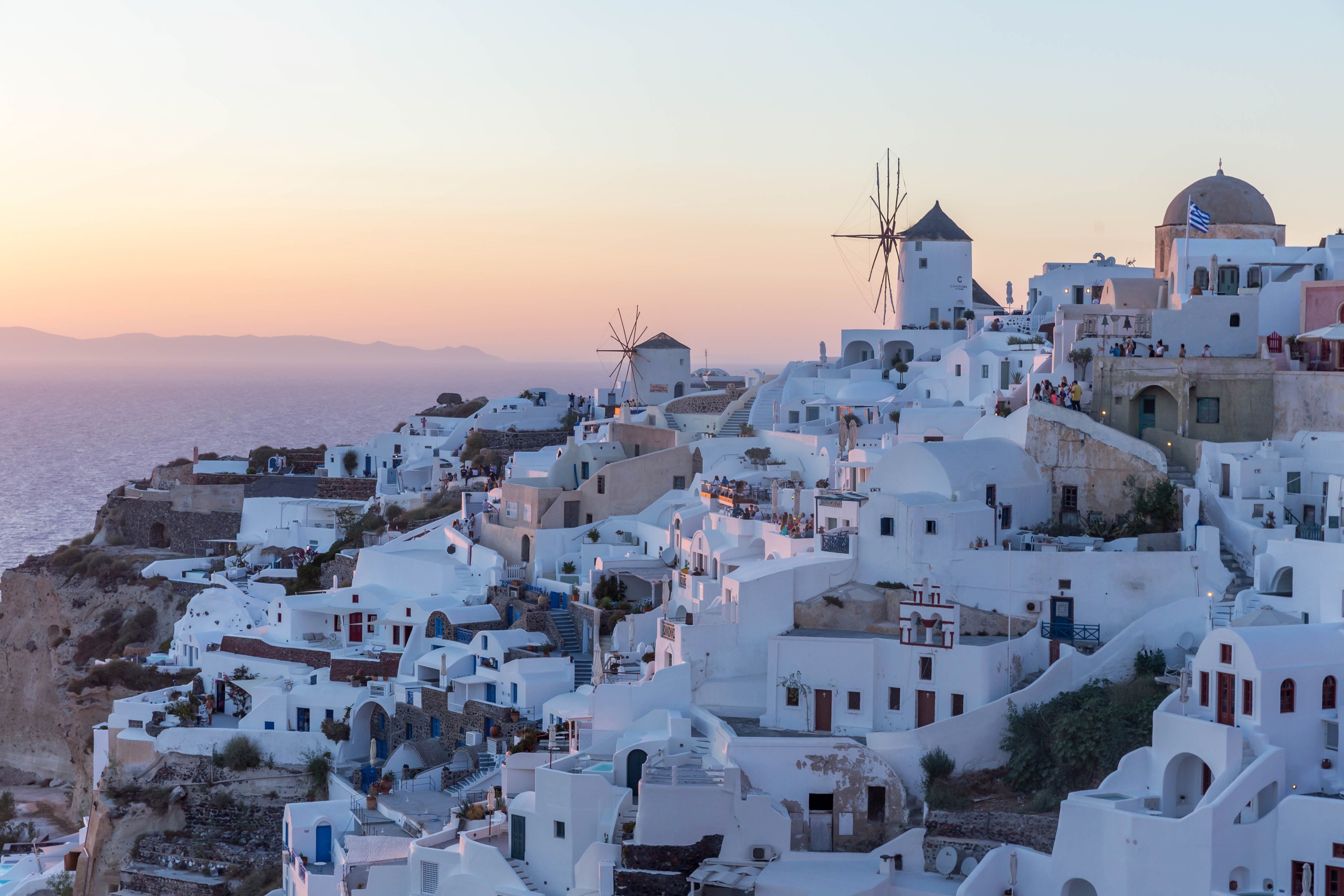 White houses and windmills in Oia, Santorini at sunset HD Wallpaper