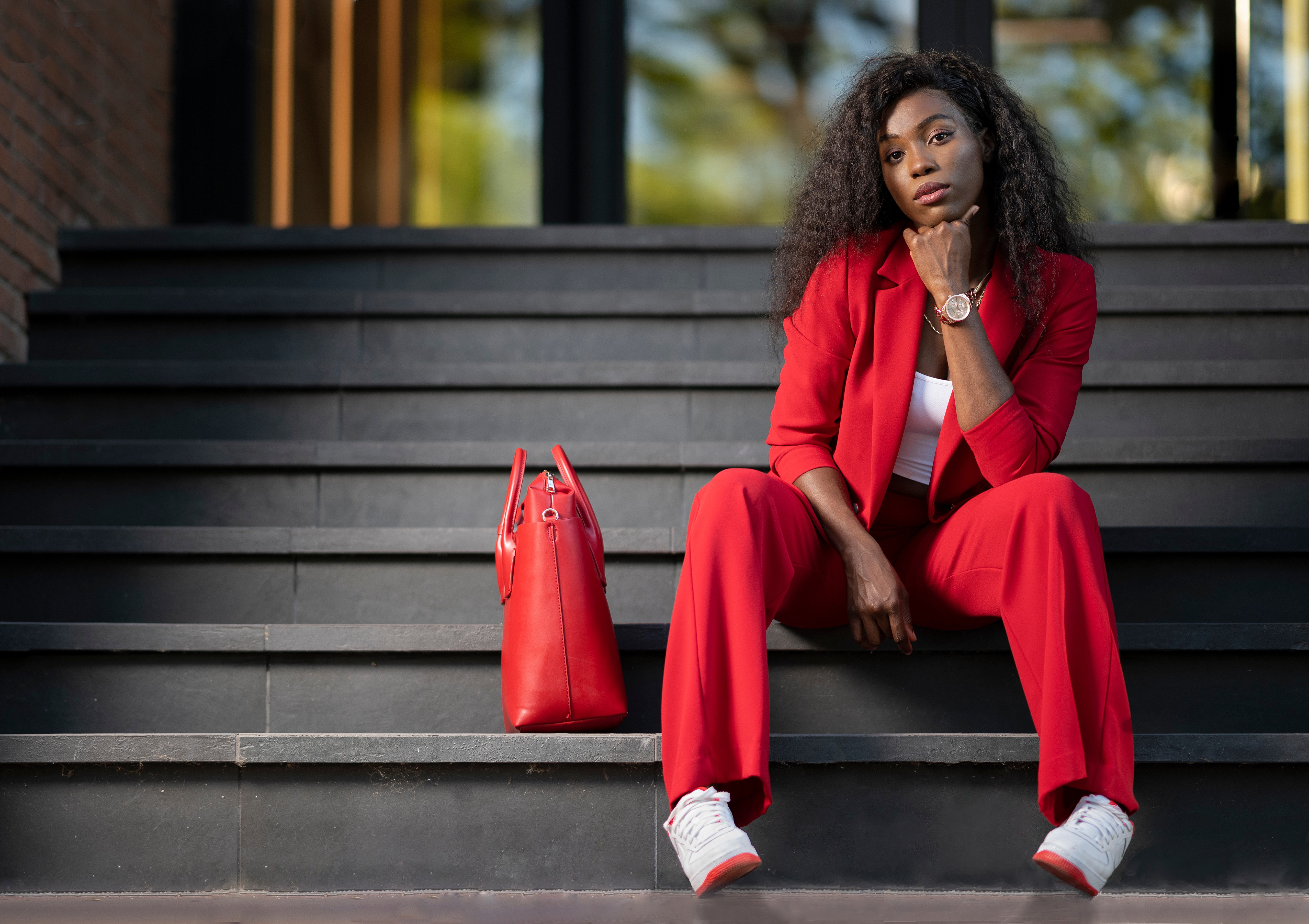Woman in red suit sitting on stairs with handbag HD Wallpaper