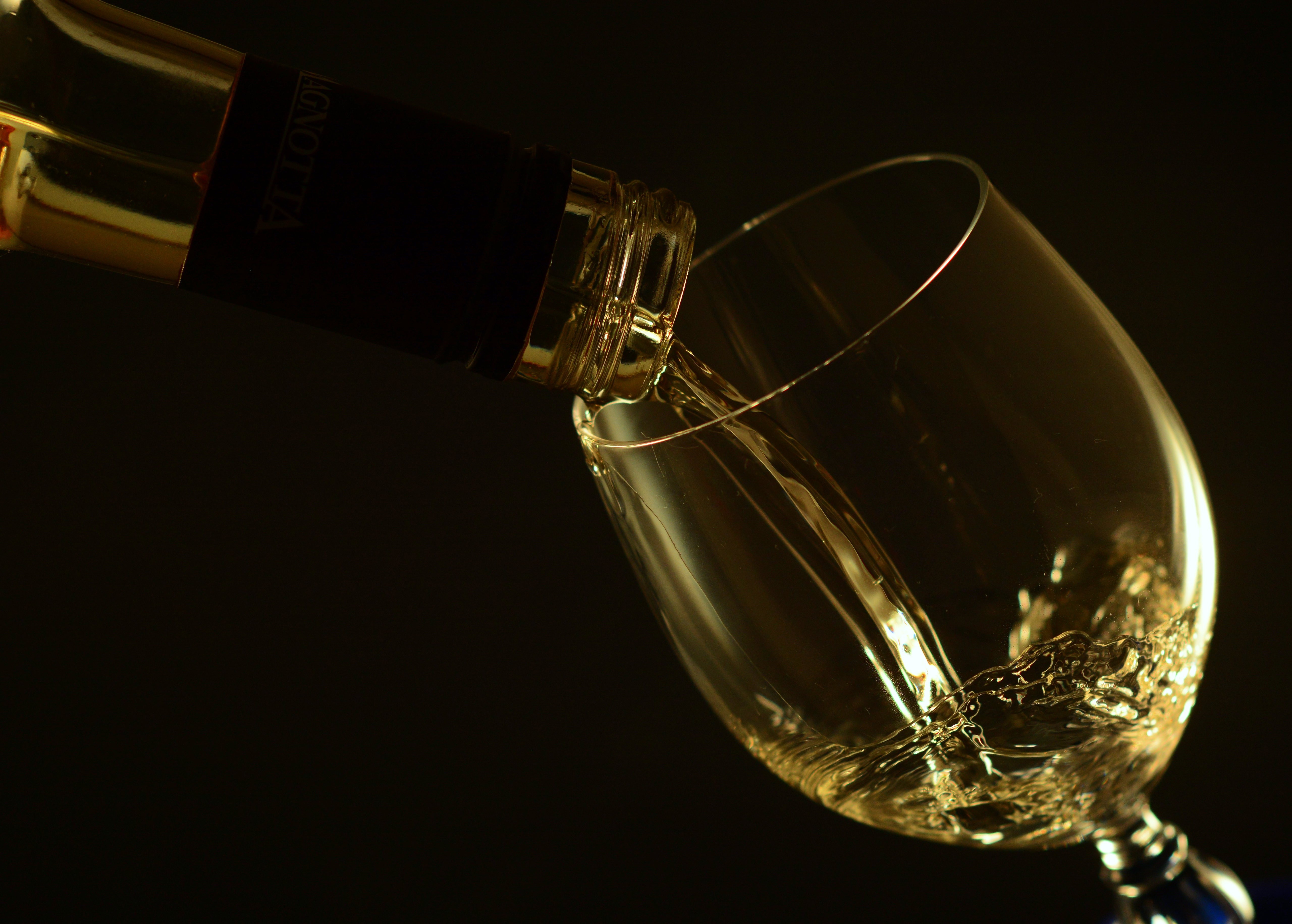 White wine being poured into a glass HD Wallpaper