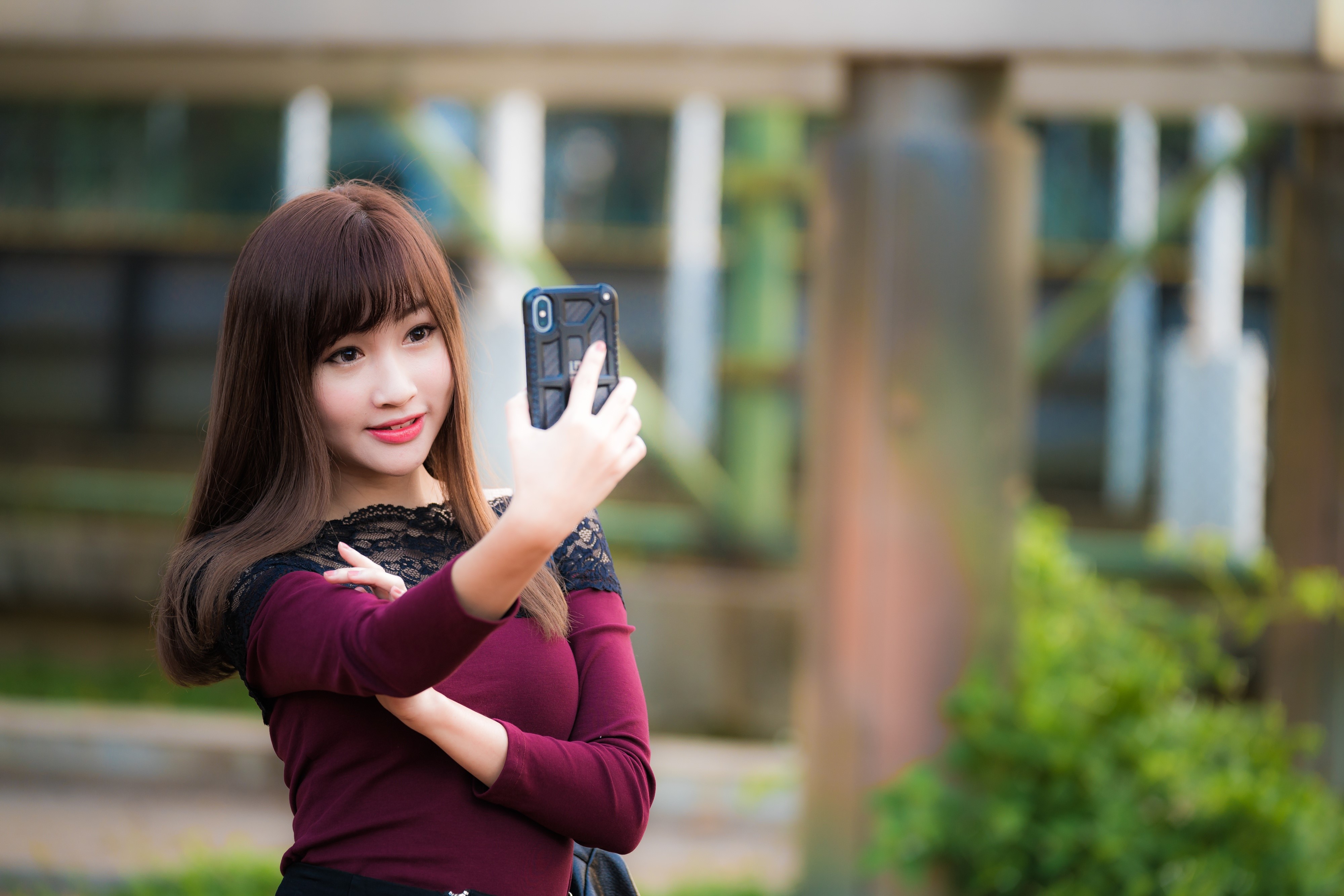 Asian woman taking a selfie with a smartphone HD Wallpaper