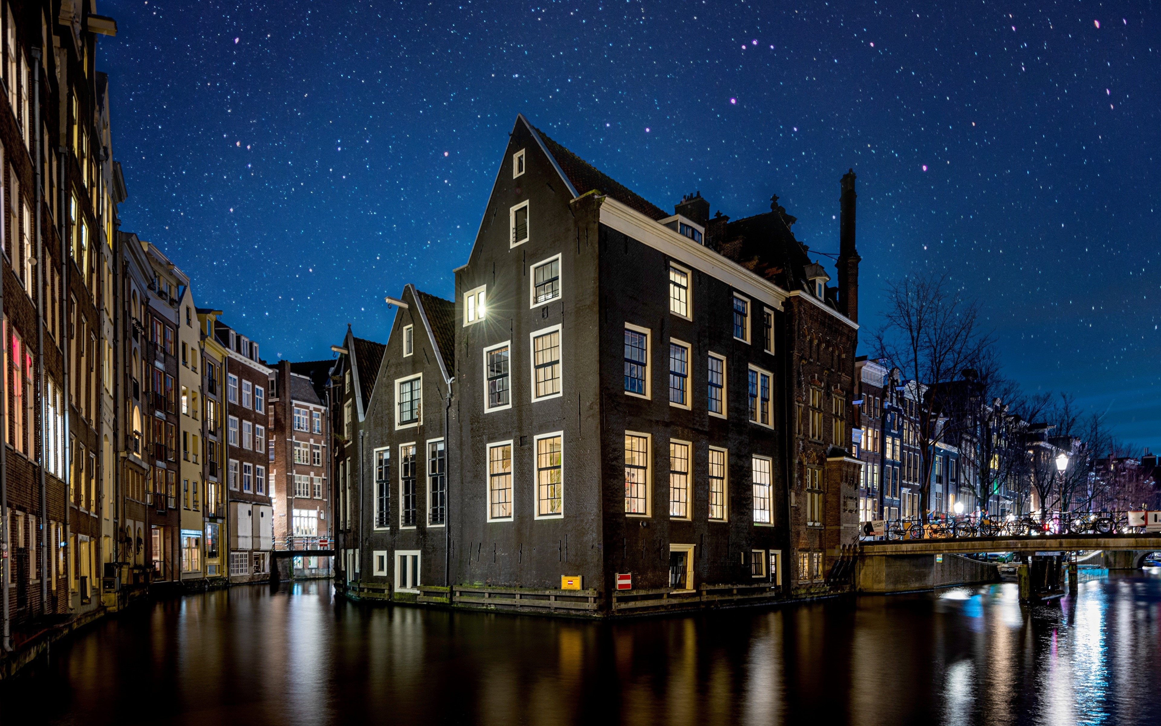 Amsterdam canal houses at night under starry sky HD Wallpaper