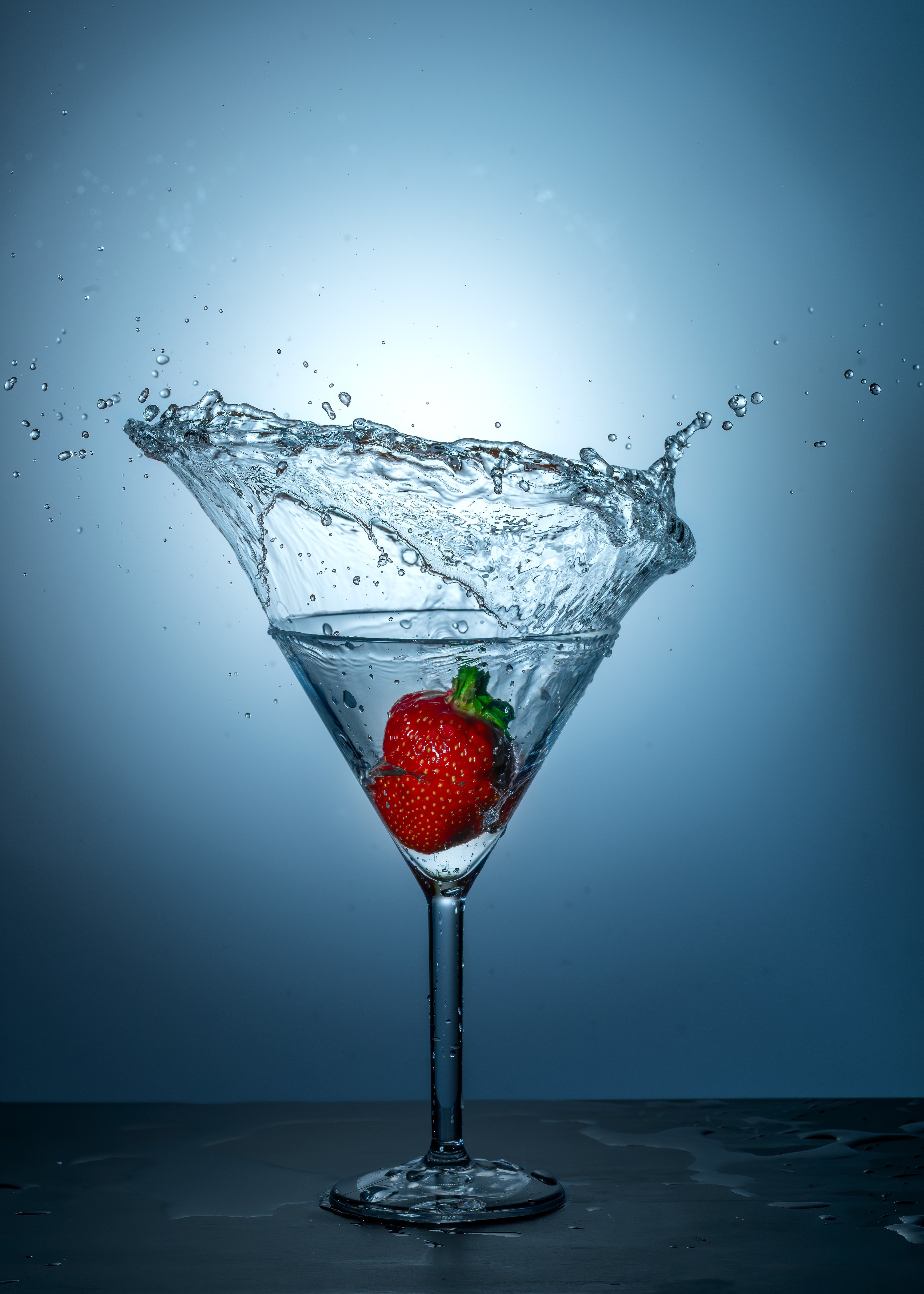 Strawberry splashing into water in a martini glass HD Phone Wallpaper