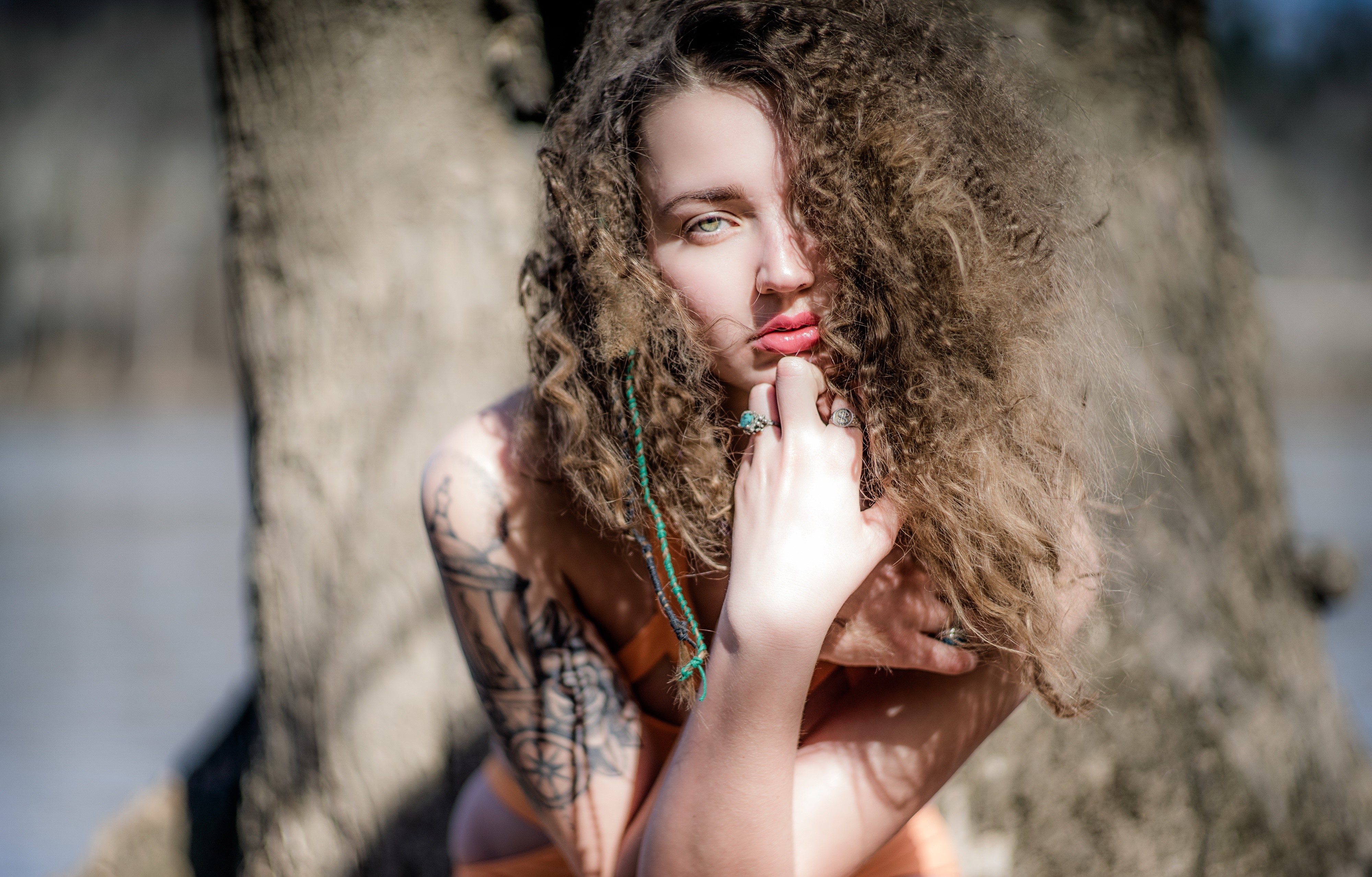 Woman with curly hair and tattoos HD Wallpaper