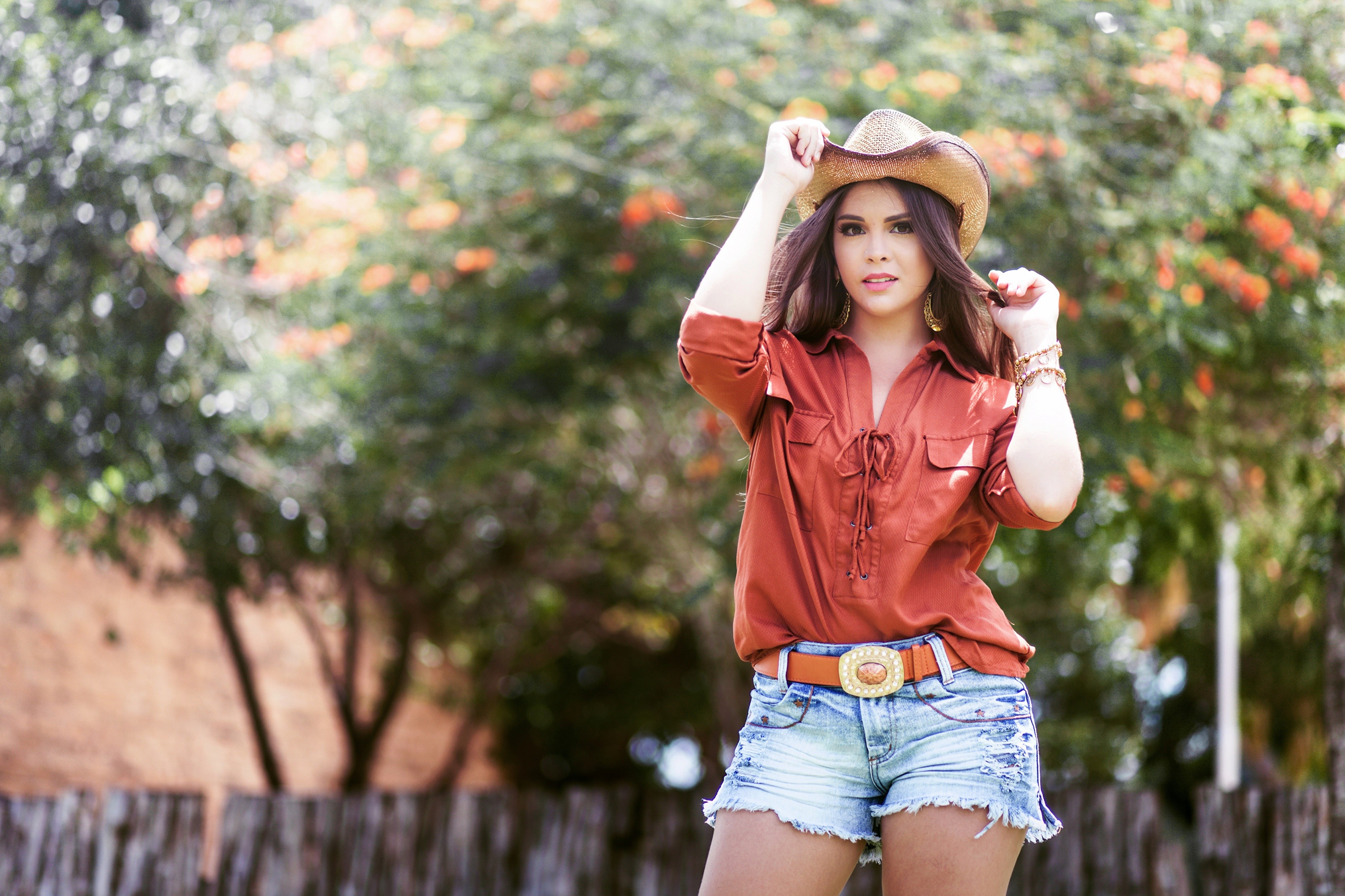 Woman in cowboy hat and denim shorts HD Wallpaper
