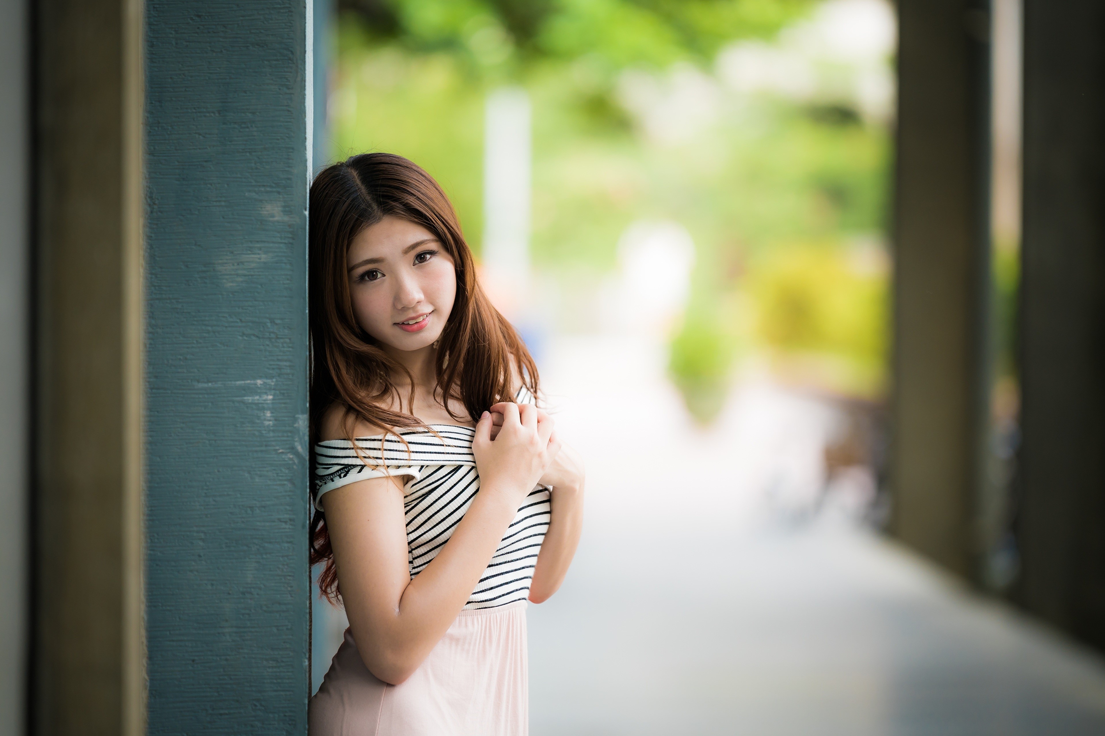 Asian woman with brown hair leaning against a pillar HD Wallpaper