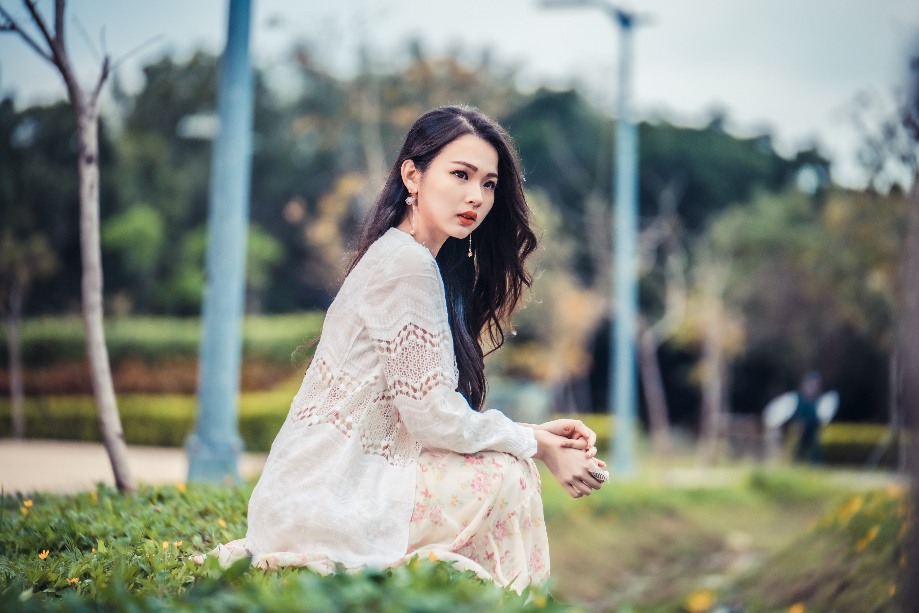 Asian woman sitting in a park HD Wallpaper