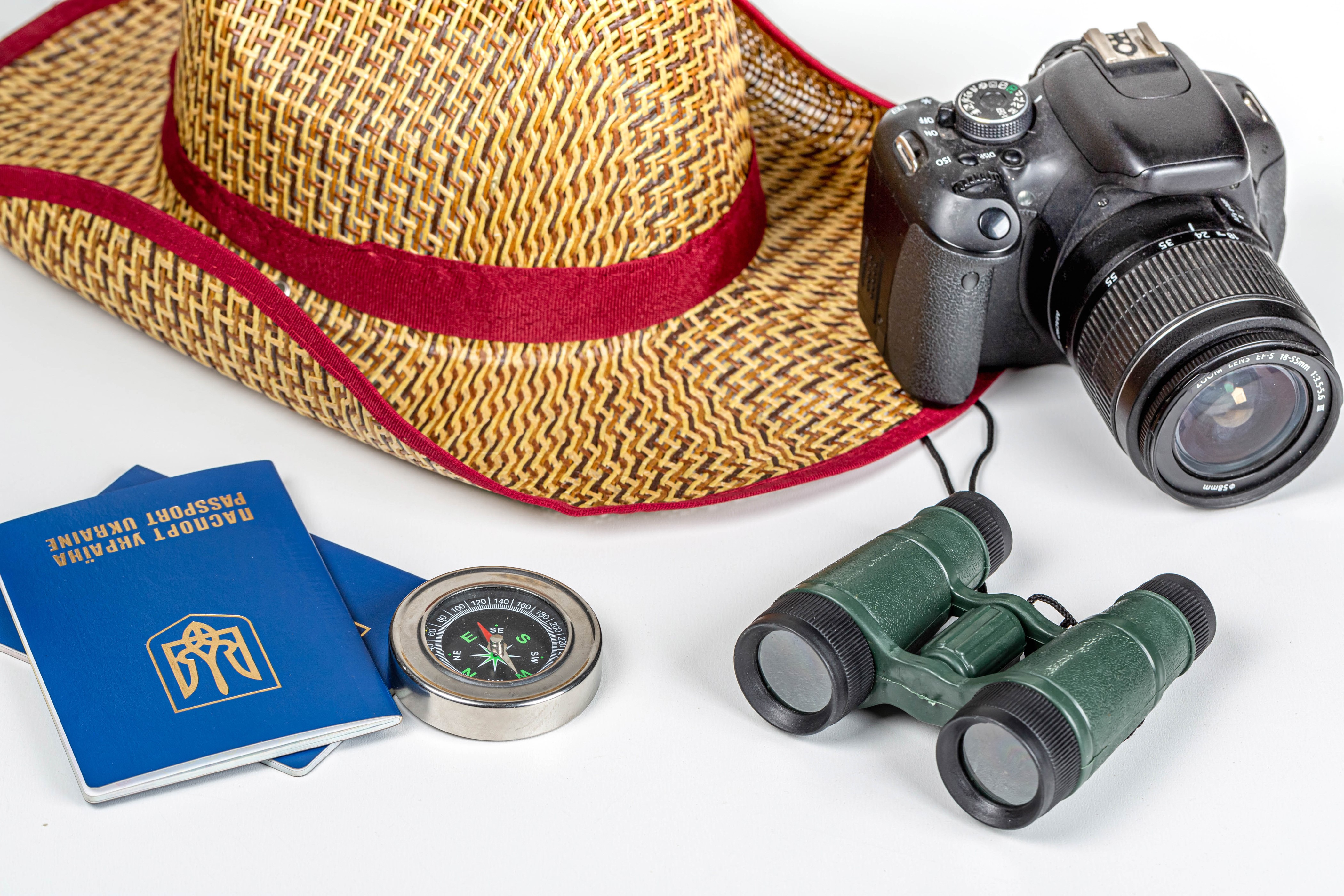 Travel essentials: Hat, camera, binoculars, passports, and compass HD Wallpaper