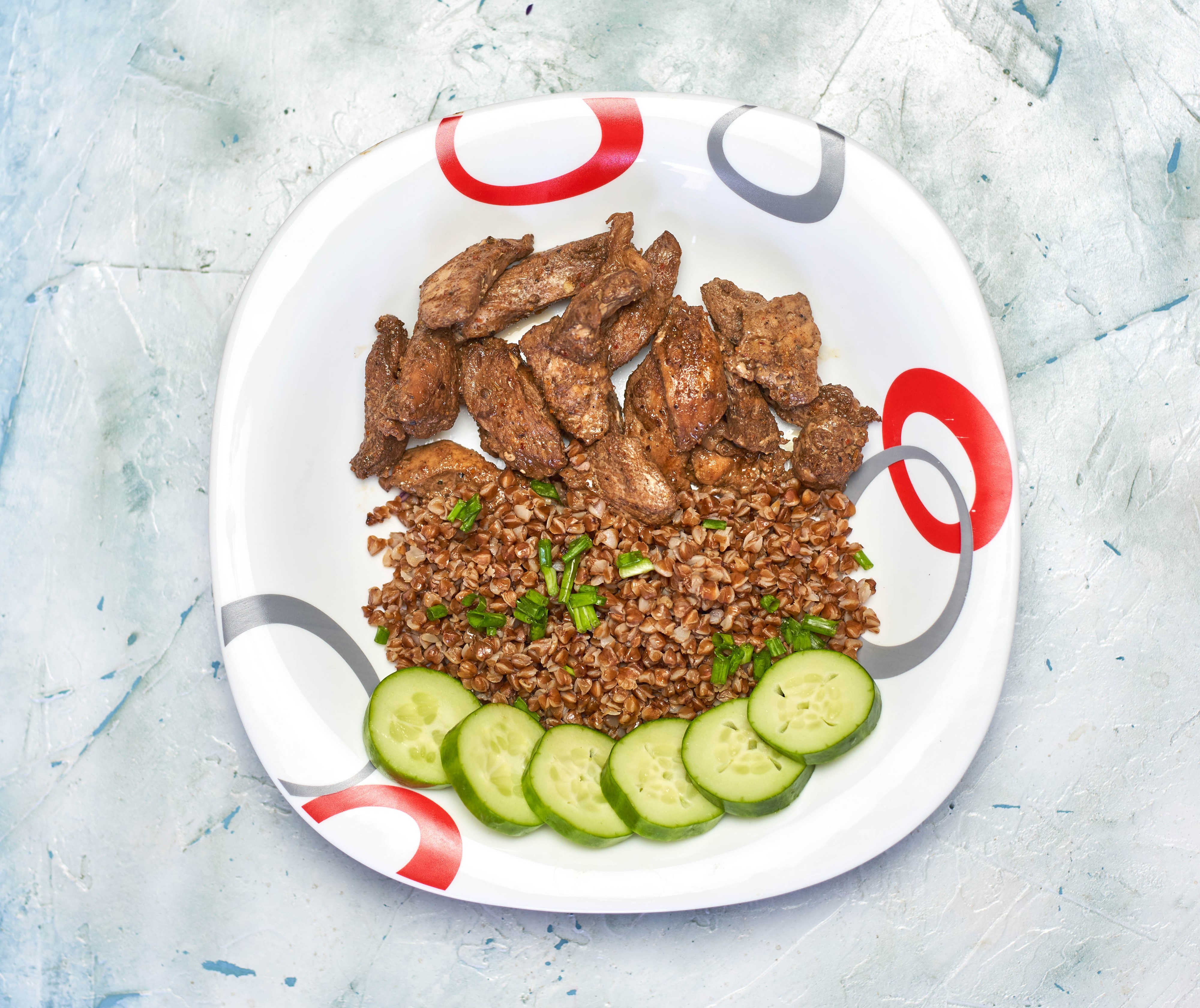 Buckwheat porridge with meat and cucumbers on a plate HD Wallpaper