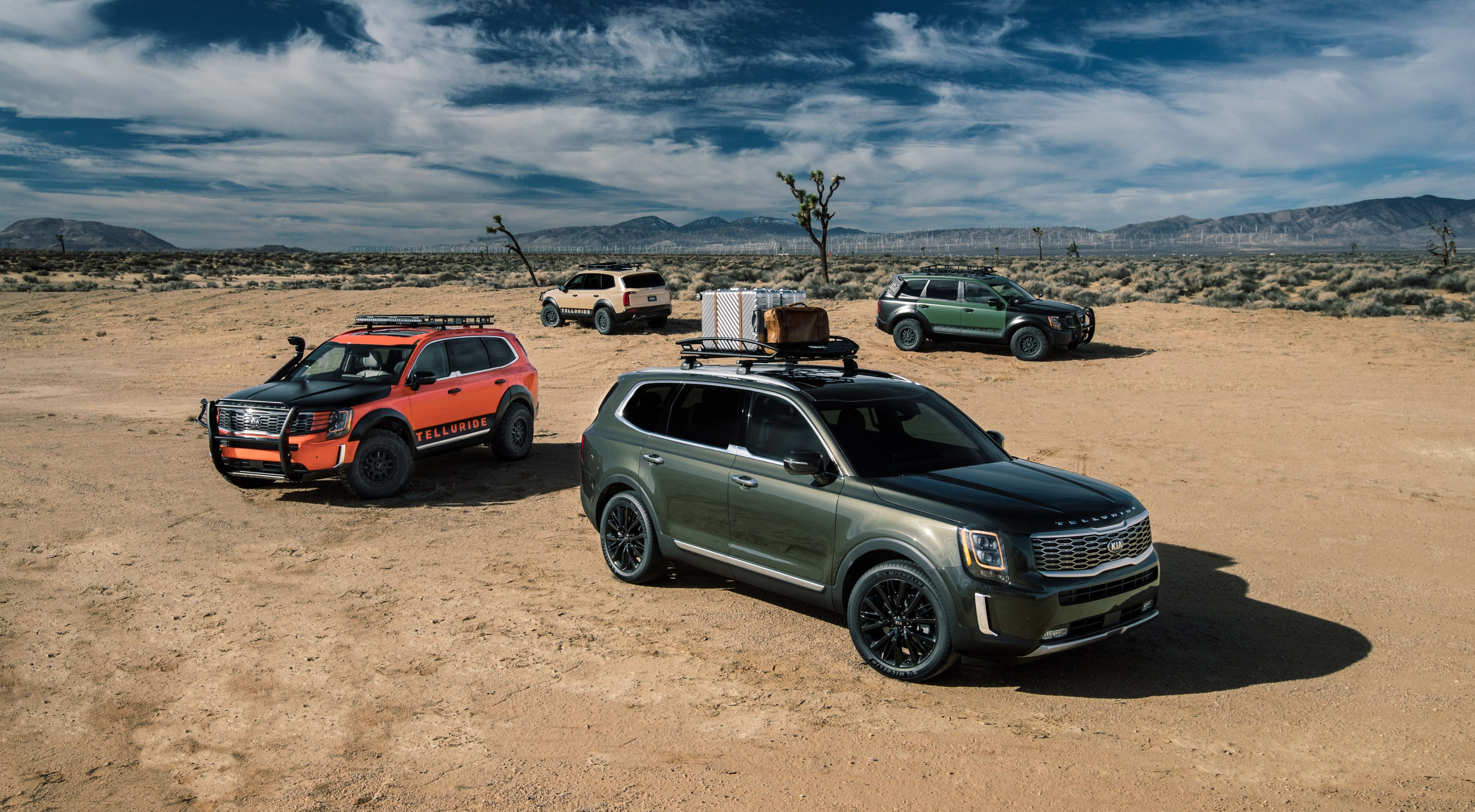 Four Kia Telluride SUVs in a desert landscape HD Wallpaper