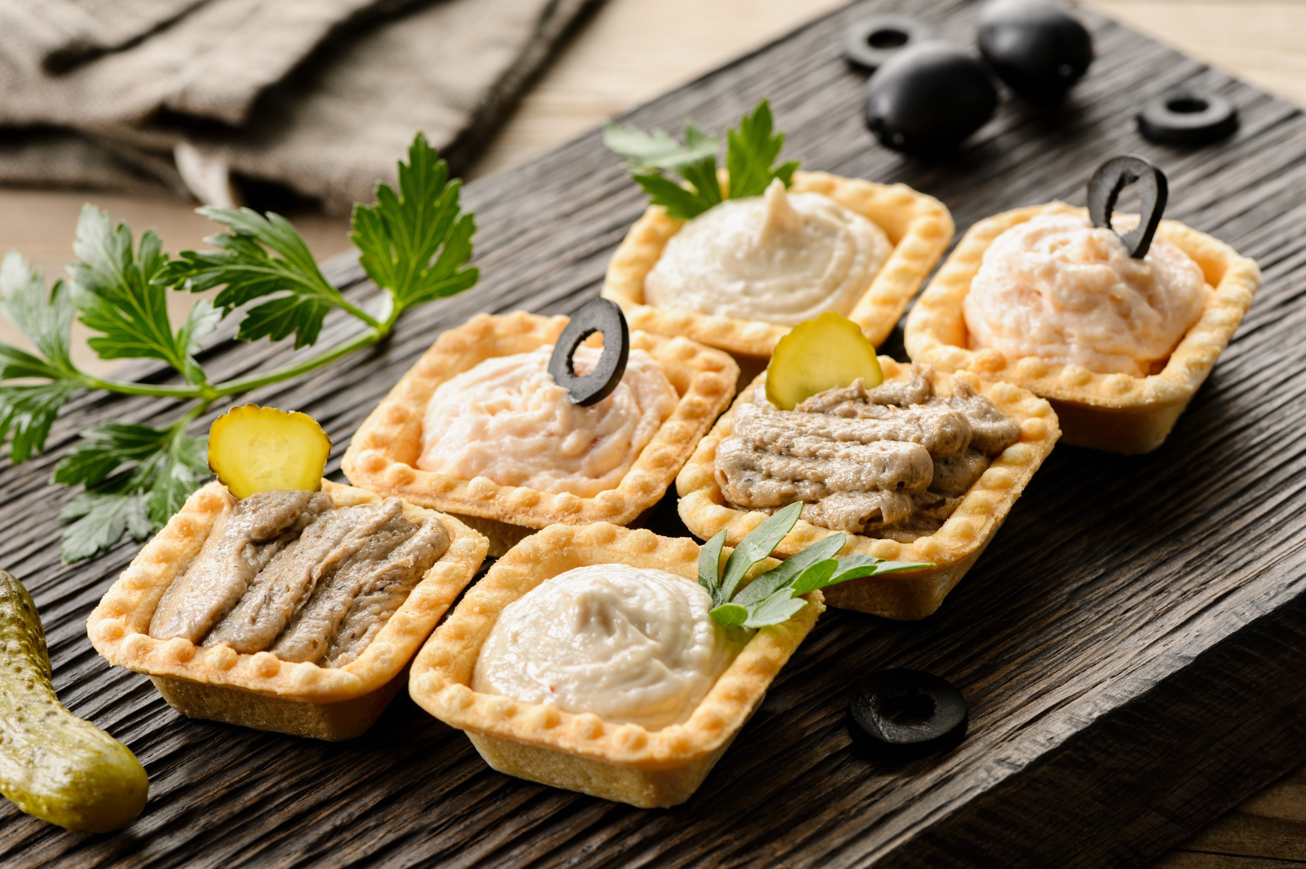 Tartlets with paste, cucumbers, and olives on a cutting board HD Wallpaper