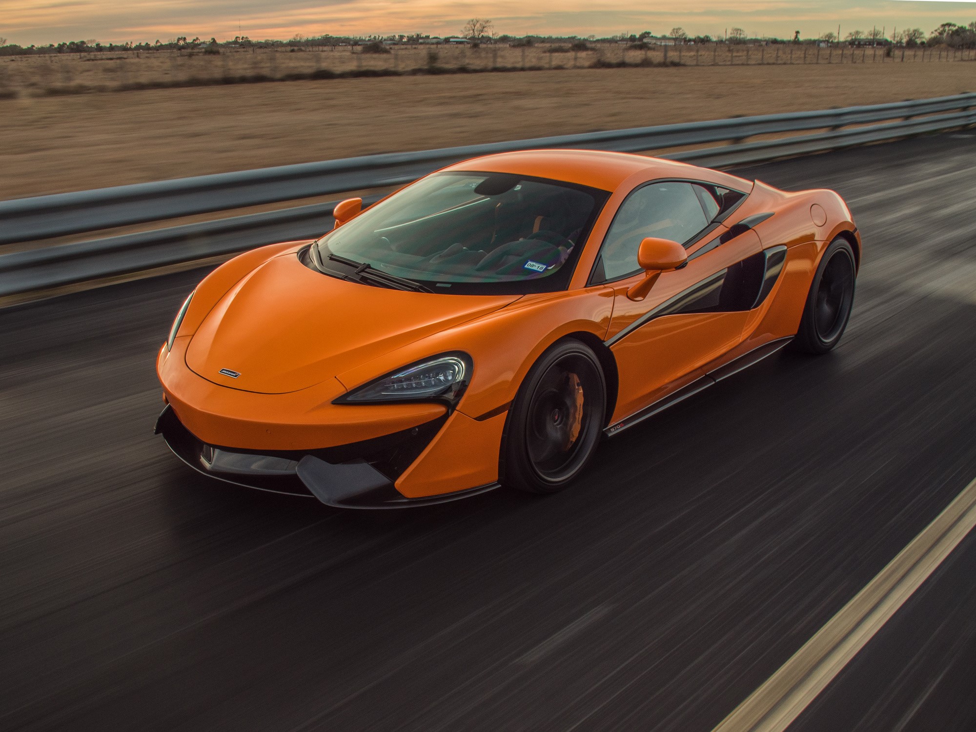 Orange McLaren 600LT driving on a track HD Wallpaper