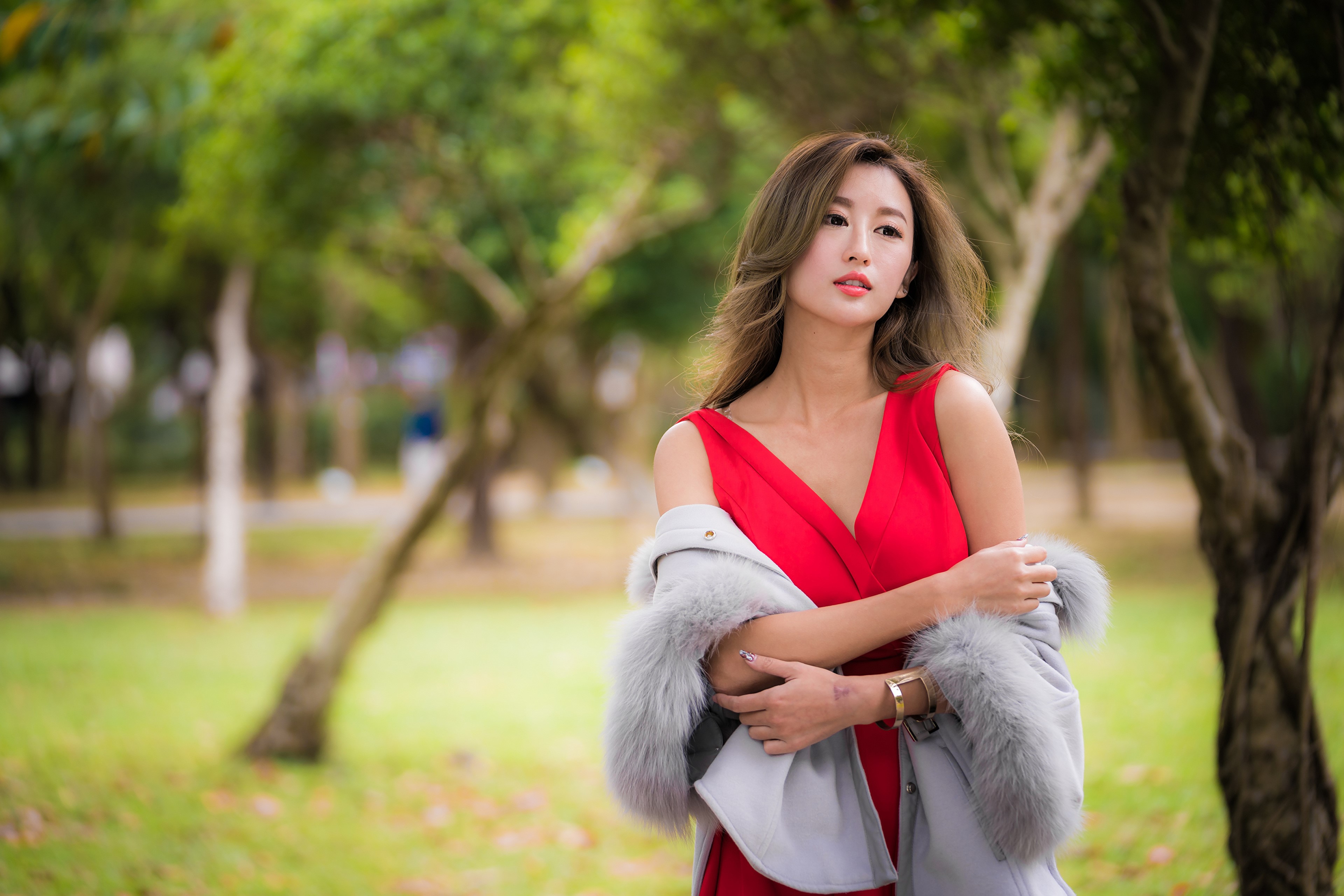 Woman in red dress with fur stole in park HD Wallpaper