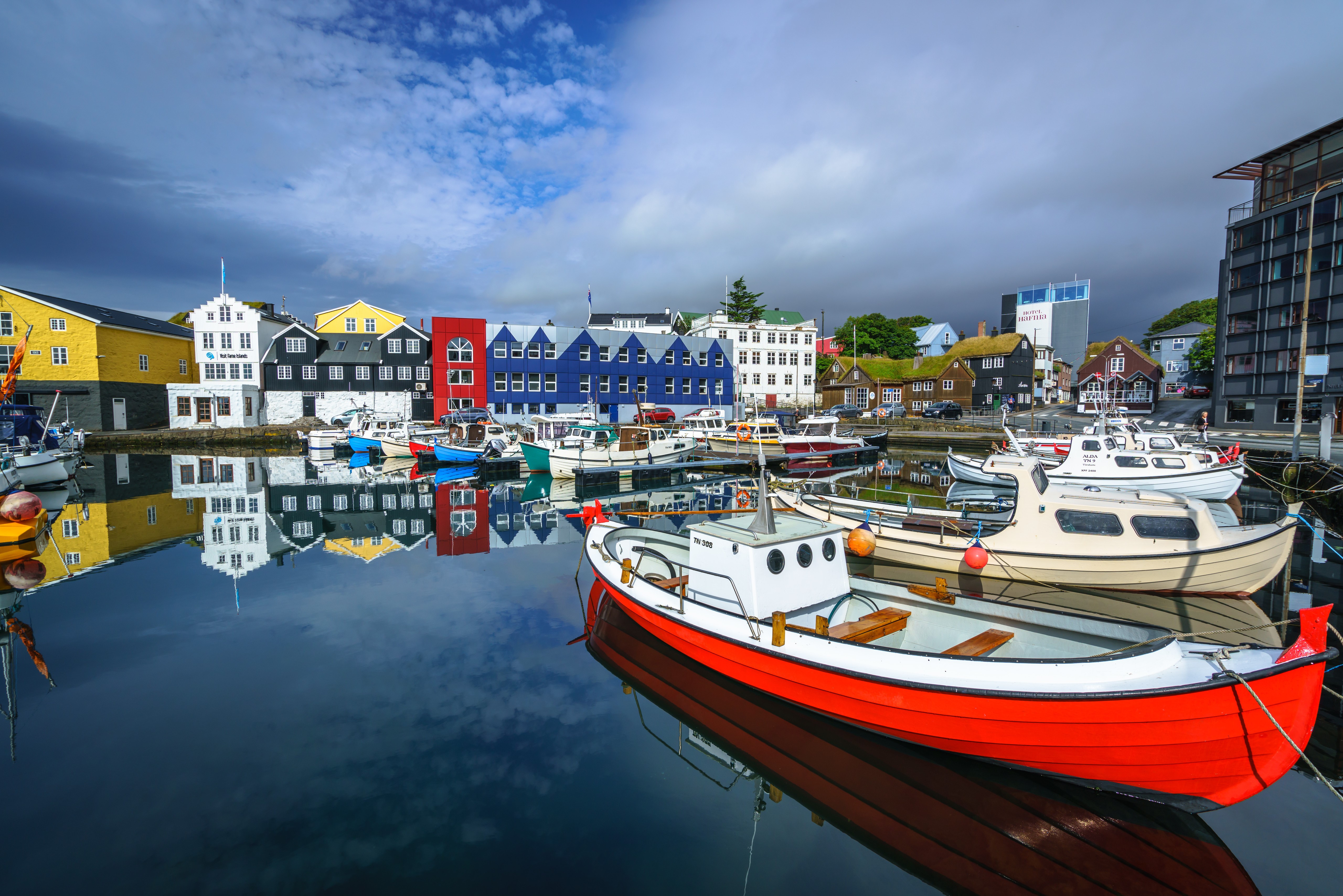 Boats docked in a colorful harbor with reflections HD Wallpaper