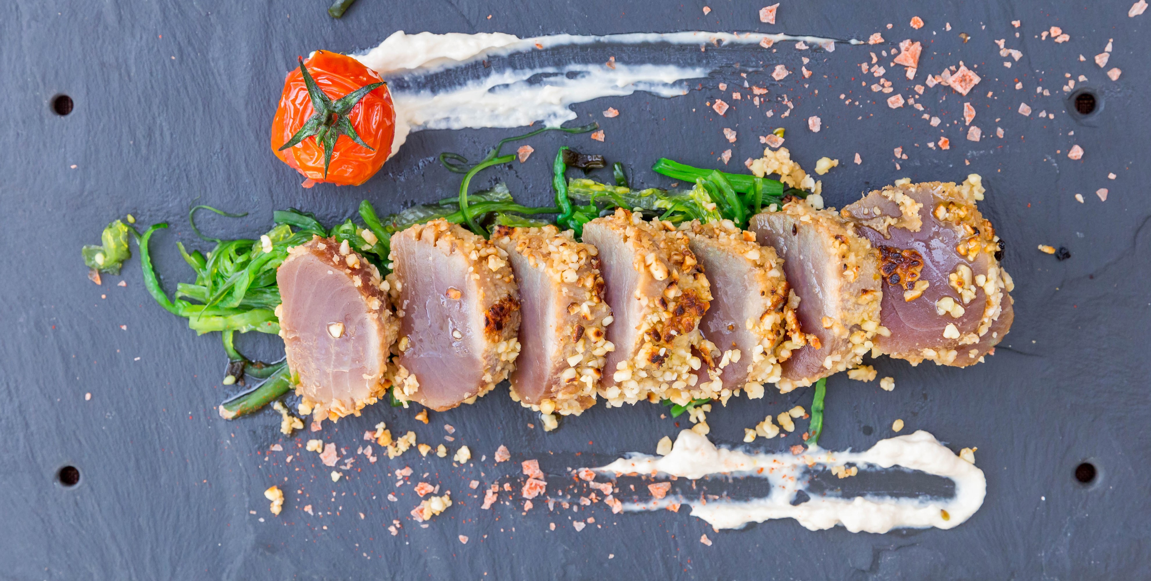 Sliced tuna with nuts, tomato, and greens HD Wallpaper