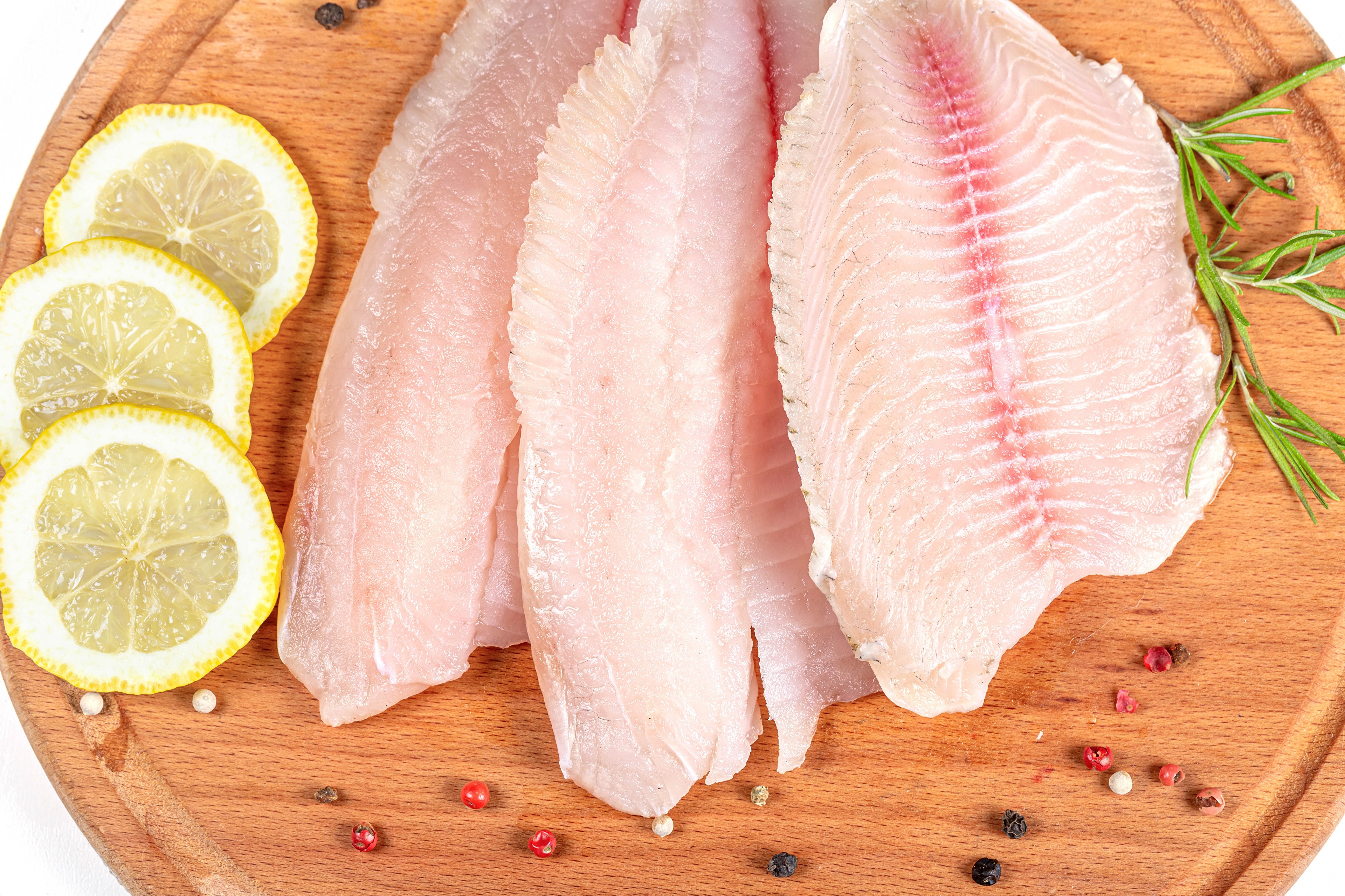 Raw Fish Fillets with Lemon Slices and Spices on Cutting Board HD Wallpaper