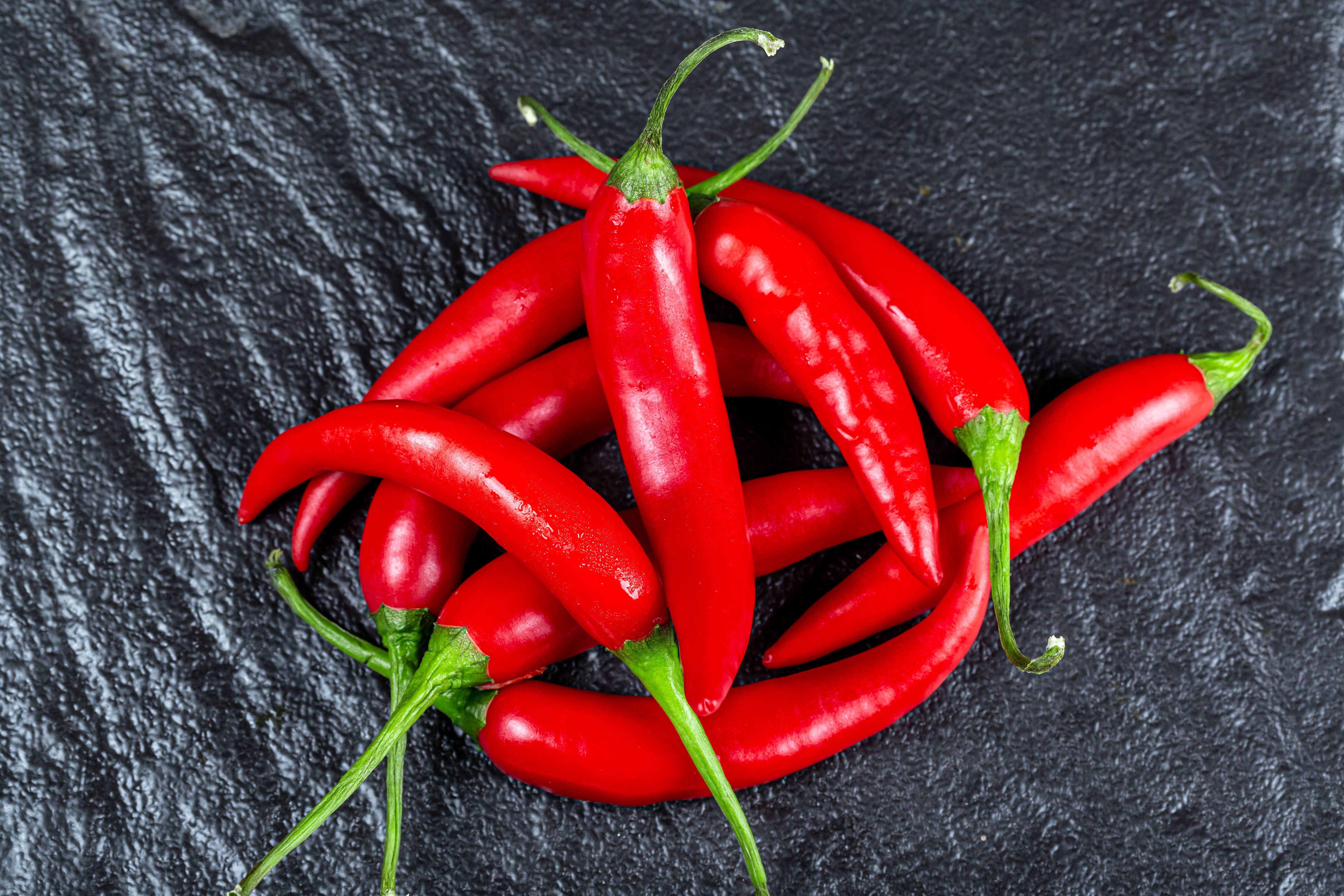 Red Chili Peppers on Dark Surface HD Wallpaper