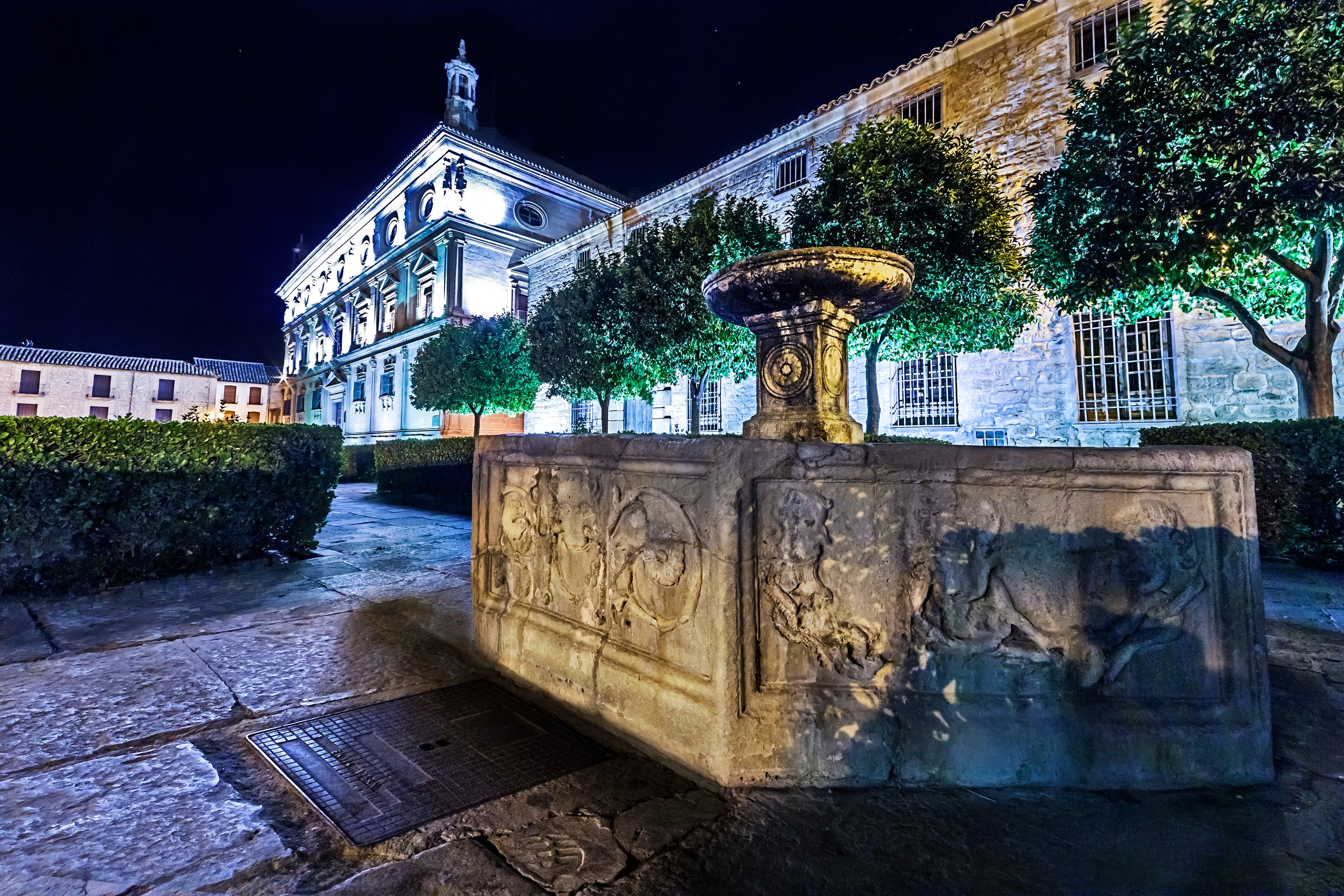 Stone fountain in front of a historic building at night HD Wallpaper