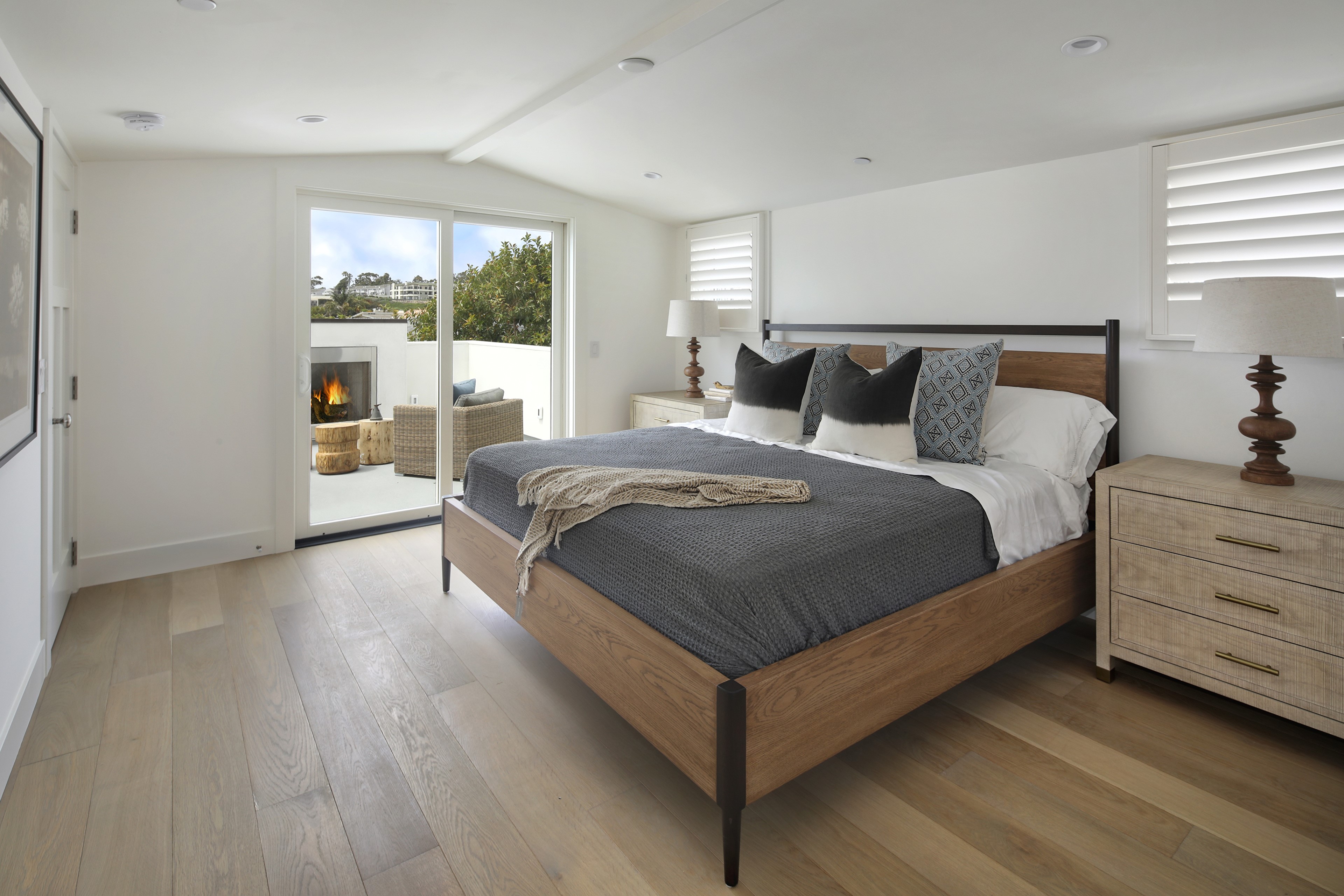 Bedroom with a bed, pillows, and a patio with a fireplace HD Wallpaper