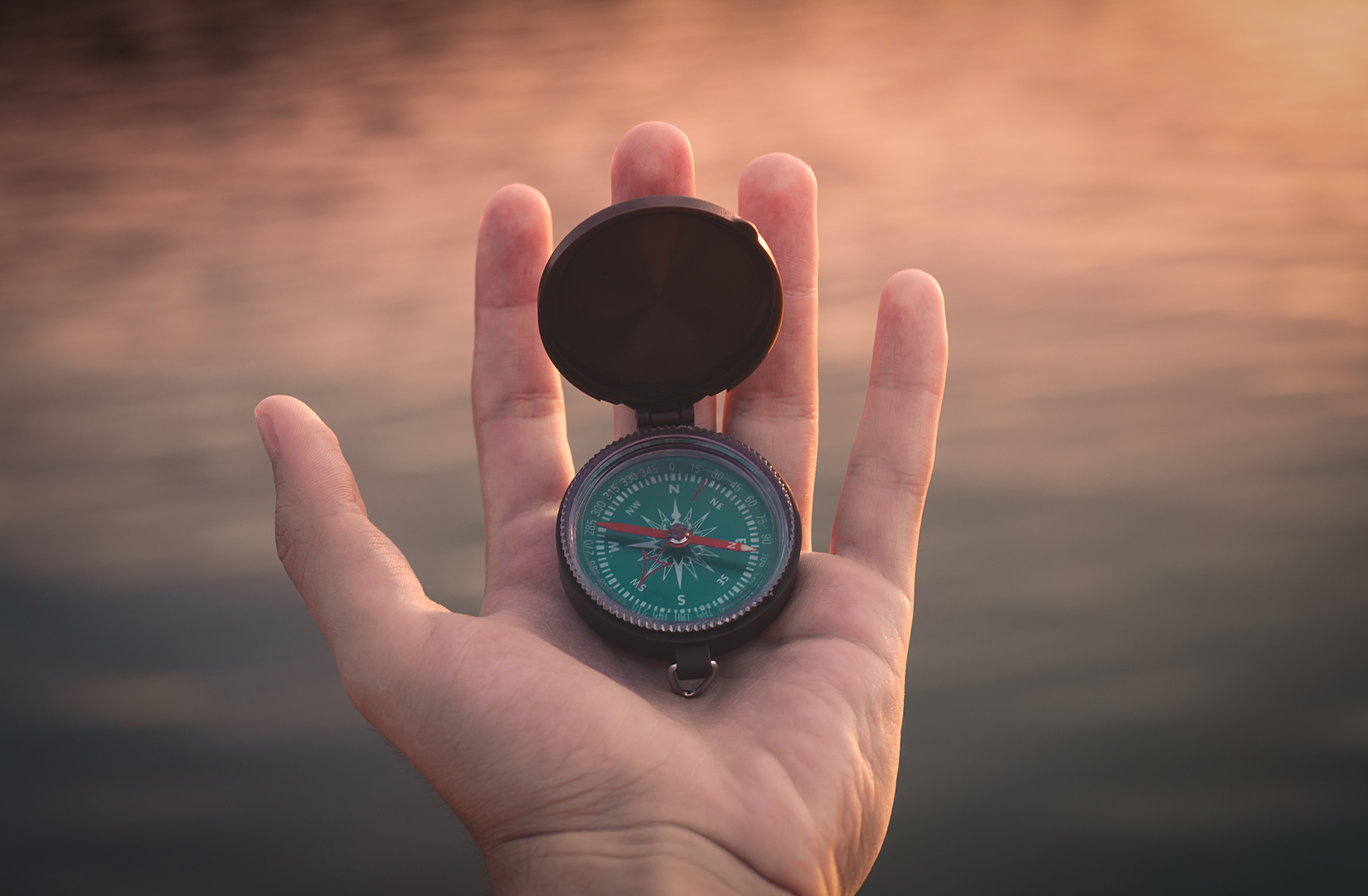 Hand holding a compass HD Wallpaper