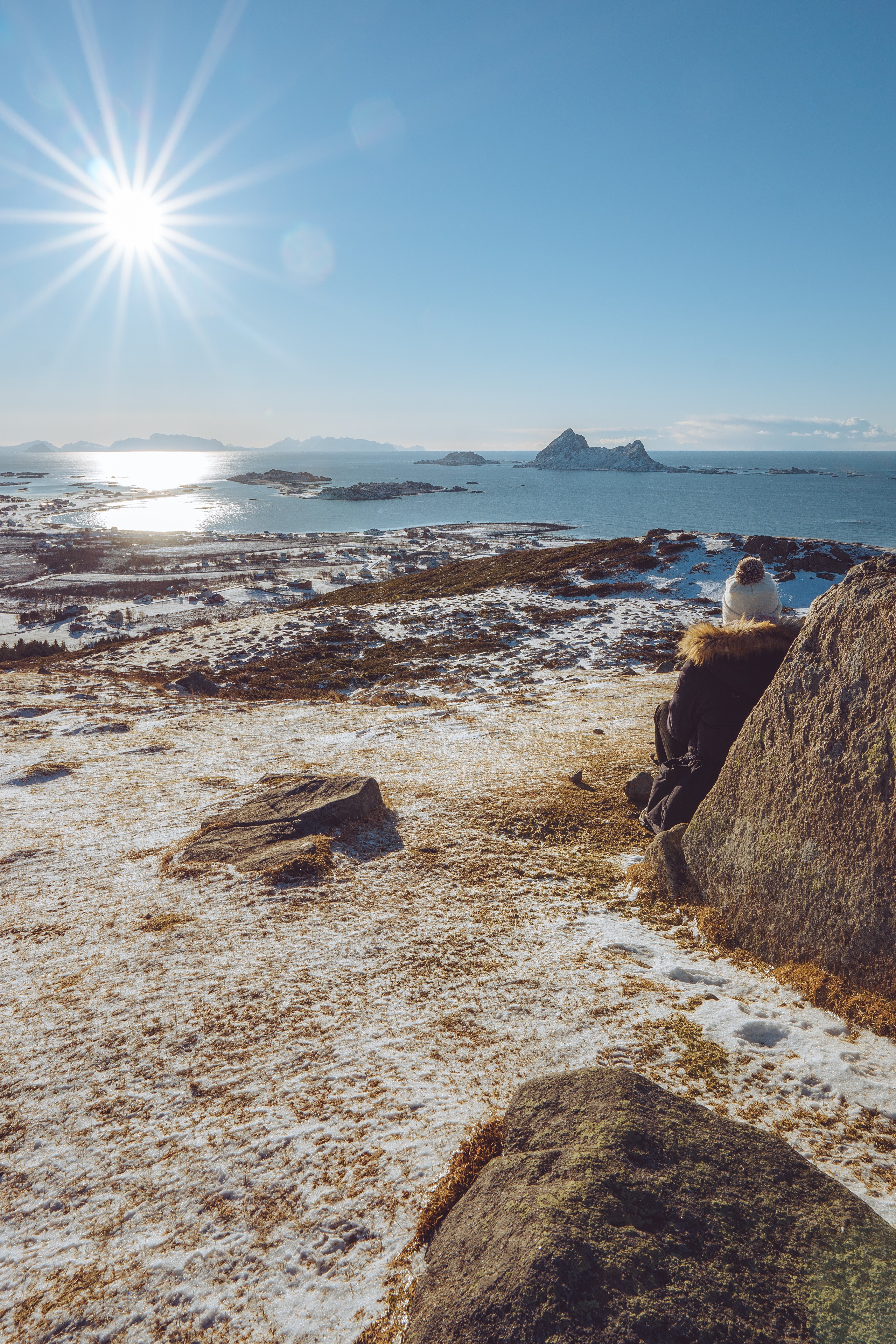 Person sitting on rocks overlooking Norwegian coast HD Phone Wallpaper