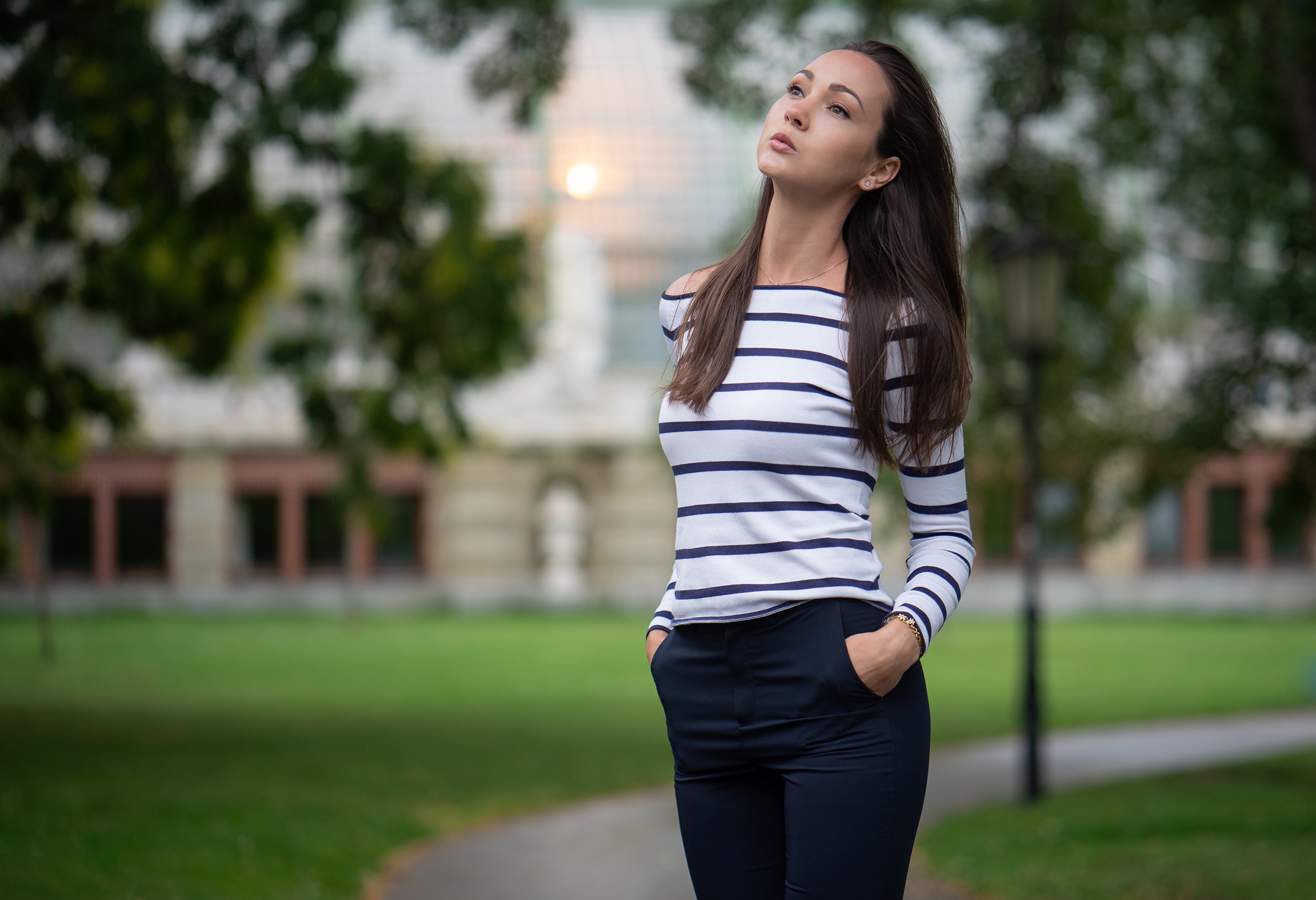 Woman in striped sweater and trousers posing outdoors HD Wallpaper