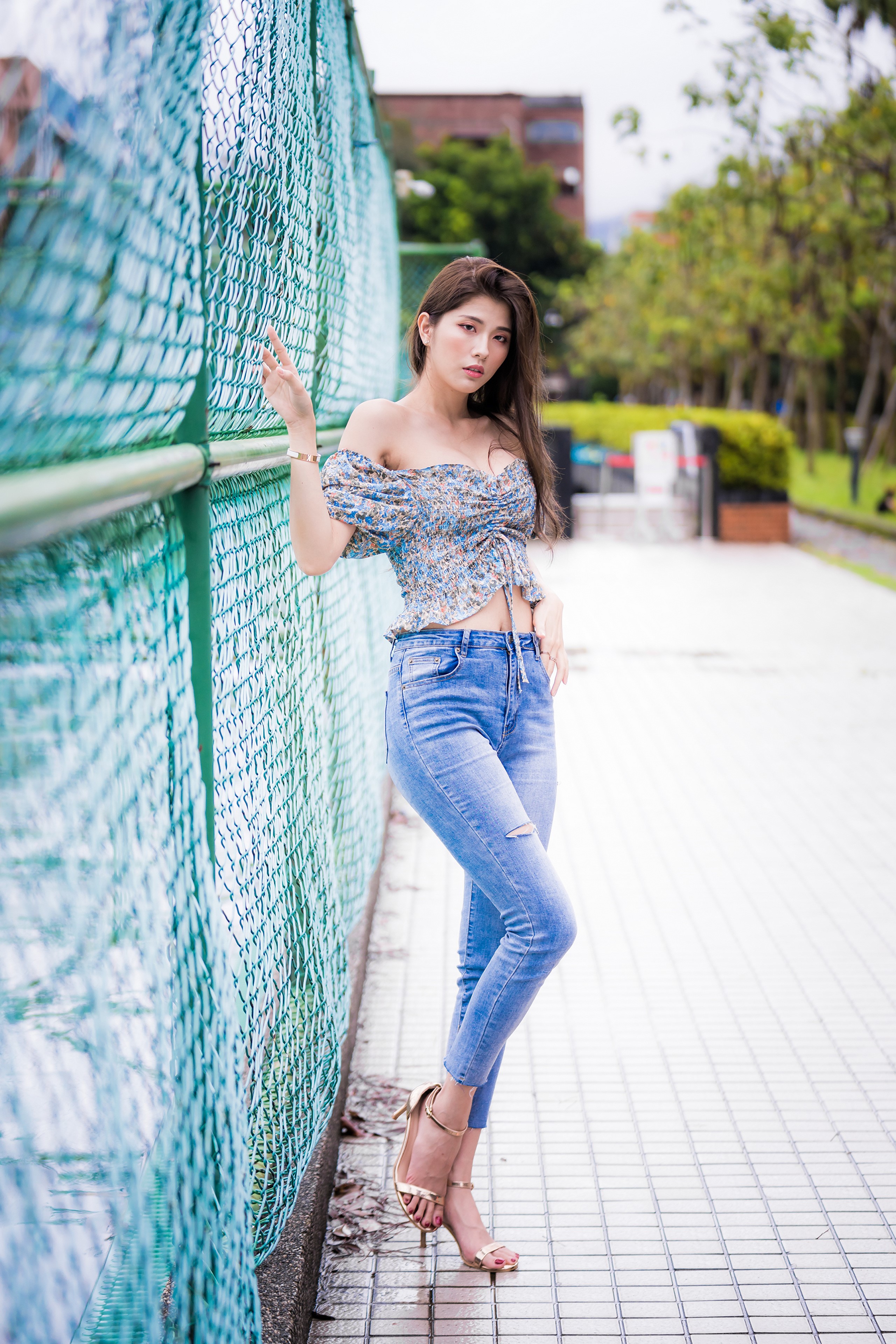 Asian Woman Posing by Fence in Jeans and Blouse HD Phone Wallpaper