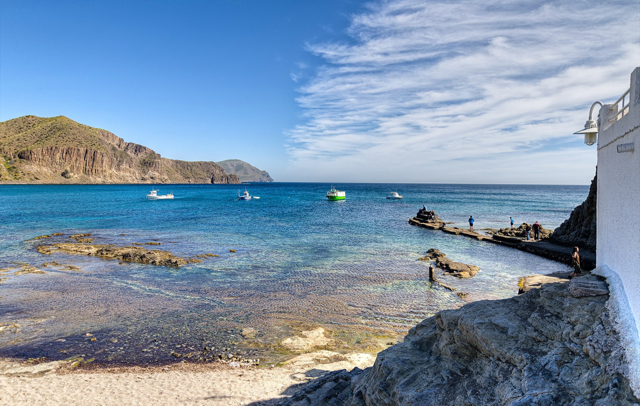 Boats in a bay with rocky coastline and mountains in Spain HD Wallpaper