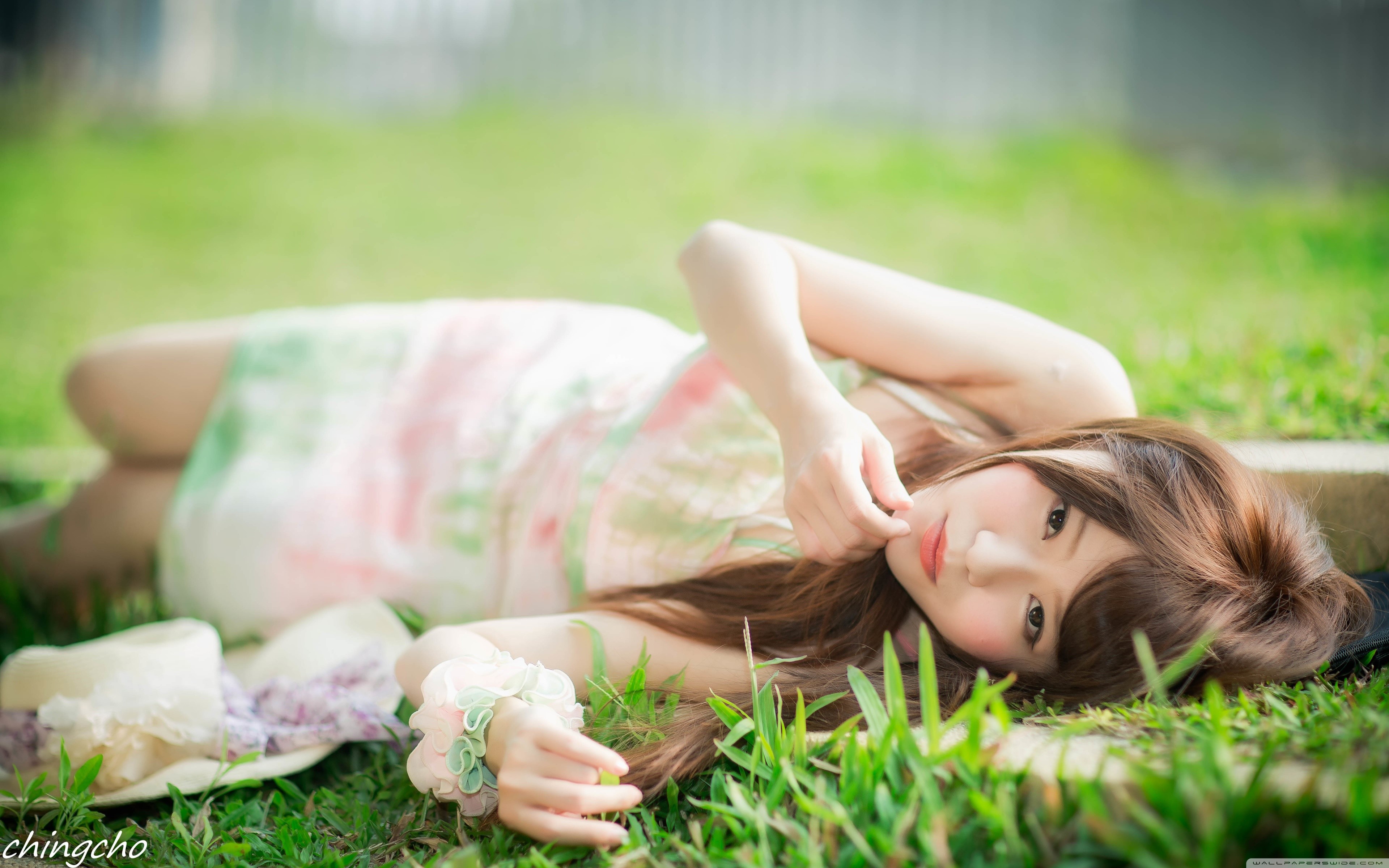 Asian woman with brown hair lying on grass HD Wallpaper