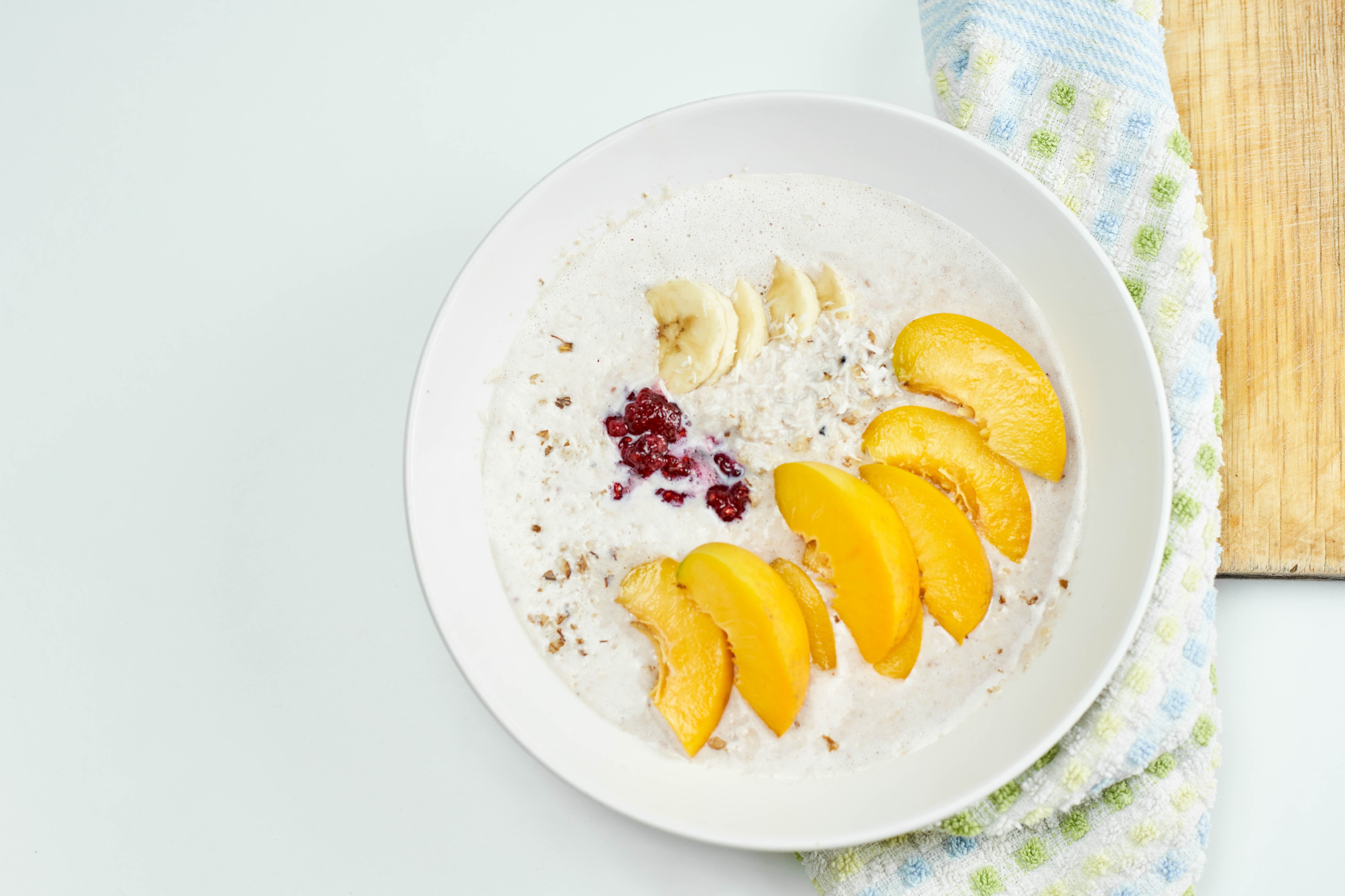 Muesli with Bananas, Peaches, and Berries on a Plate HD Wallpaper