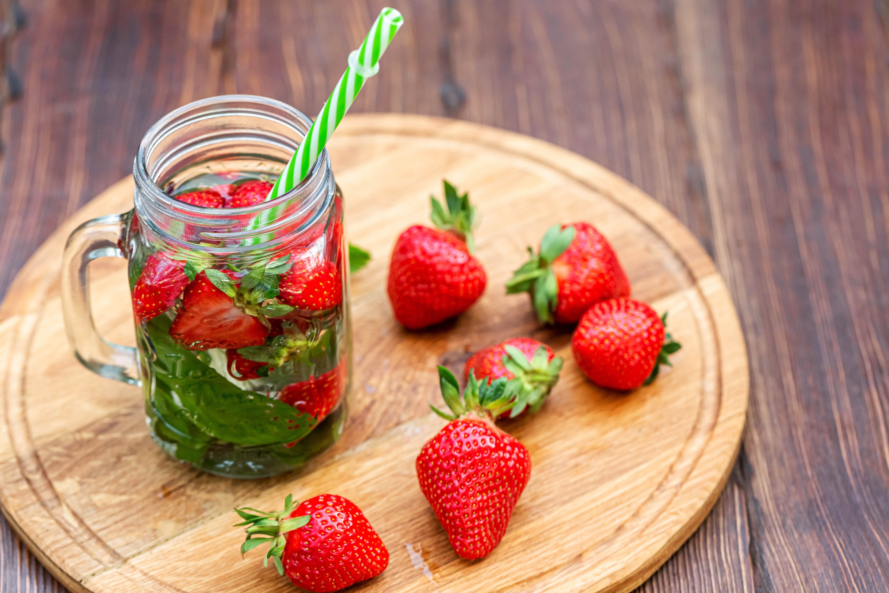 Strawberry infused water in a mason jar with fresh strawberries HD Wallpaper