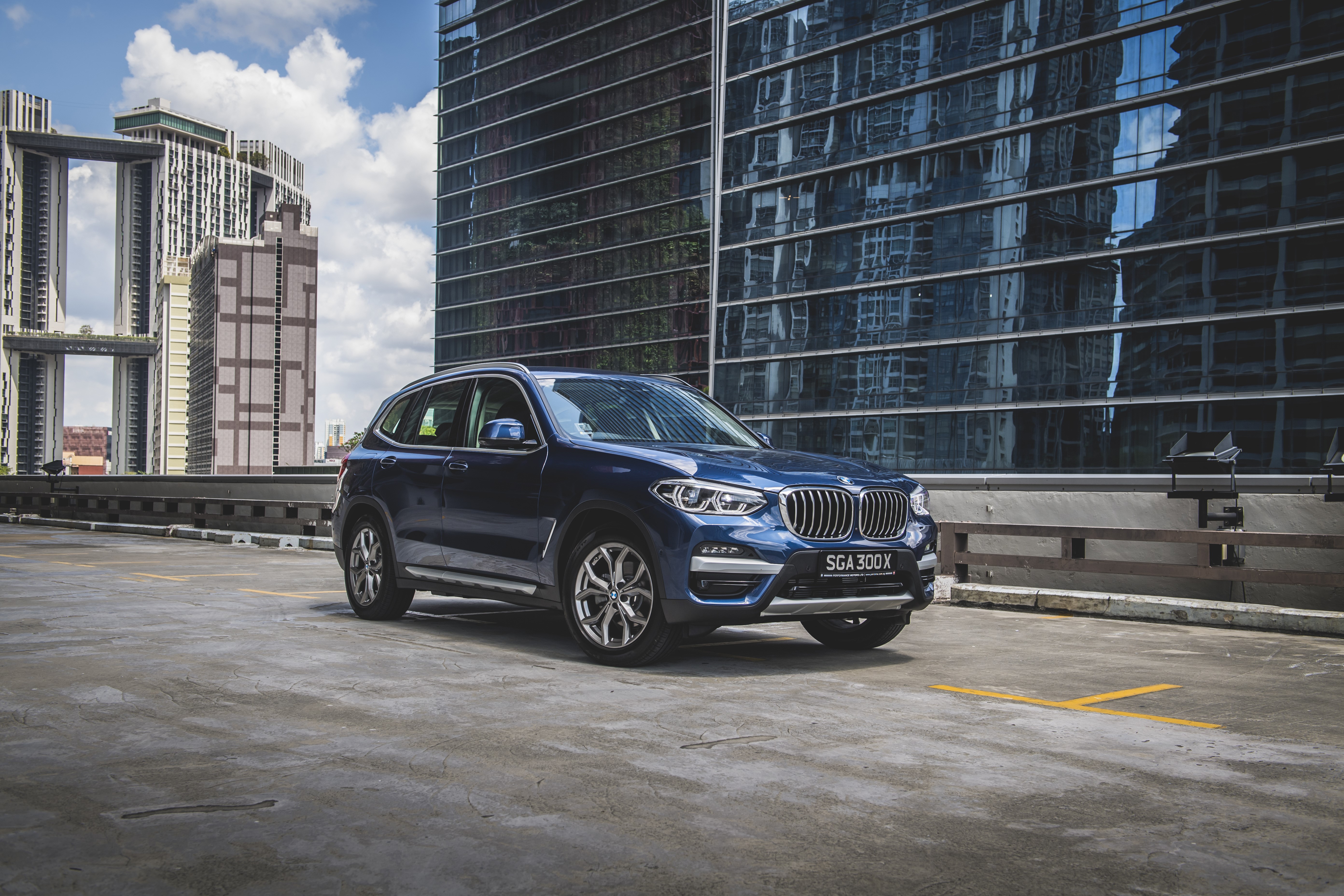 Blue BMW X3 xDrive30e xLine parked in a city HD Wallpaper