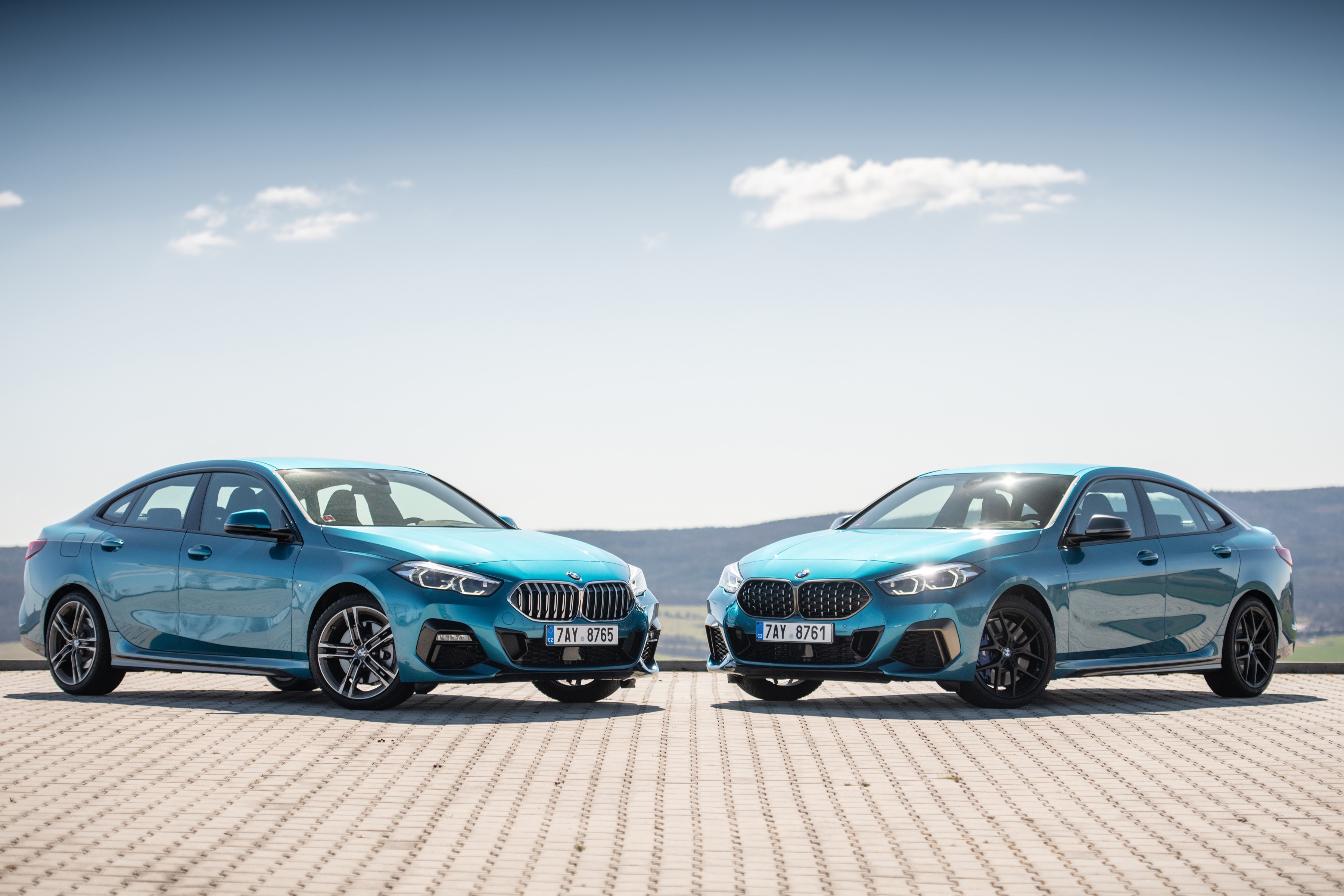 Two light blue BMW coupes parked outdoors HD Wallpaper