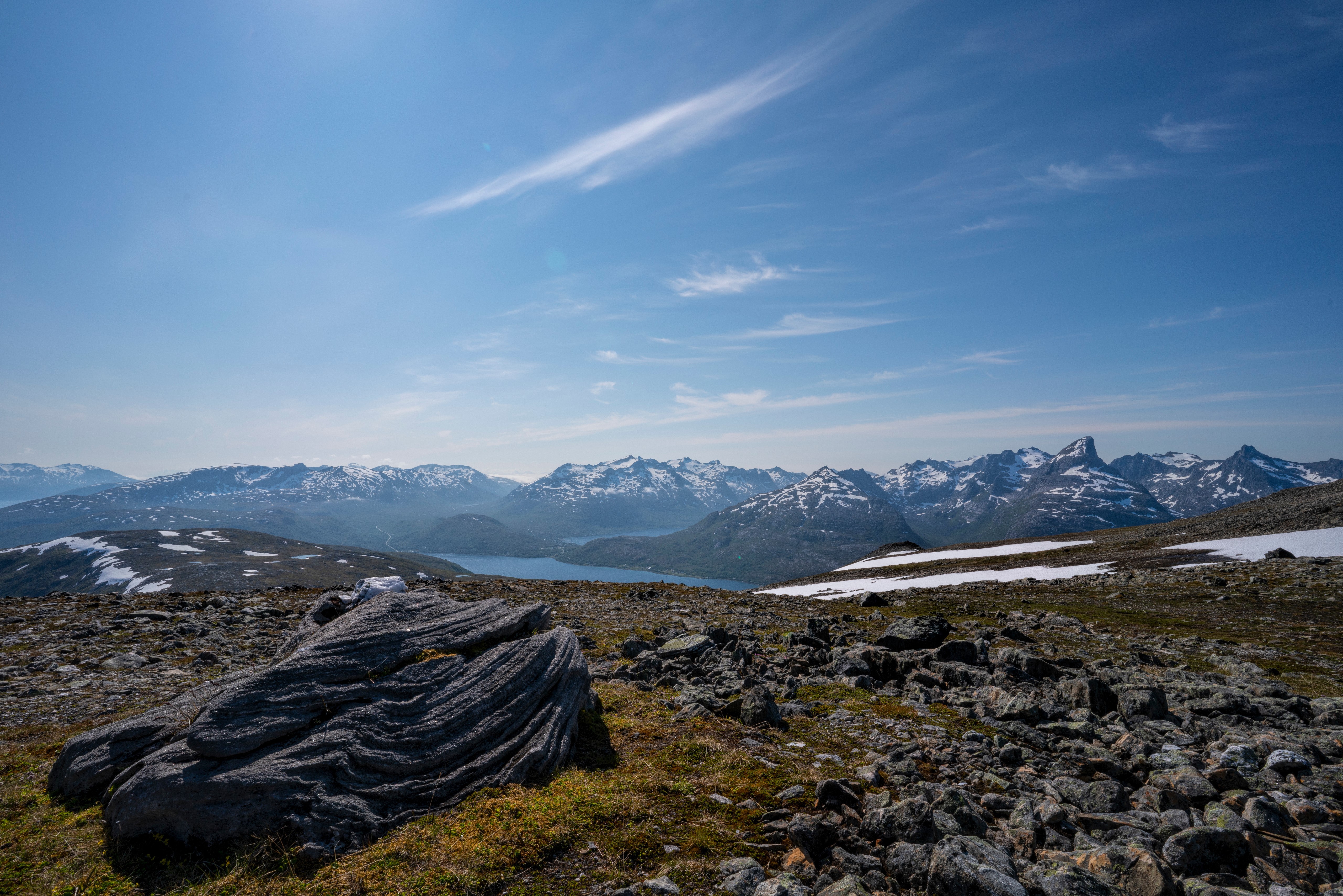 Mountains and lake in Norway with rocks in foreground HD Wallpaper
