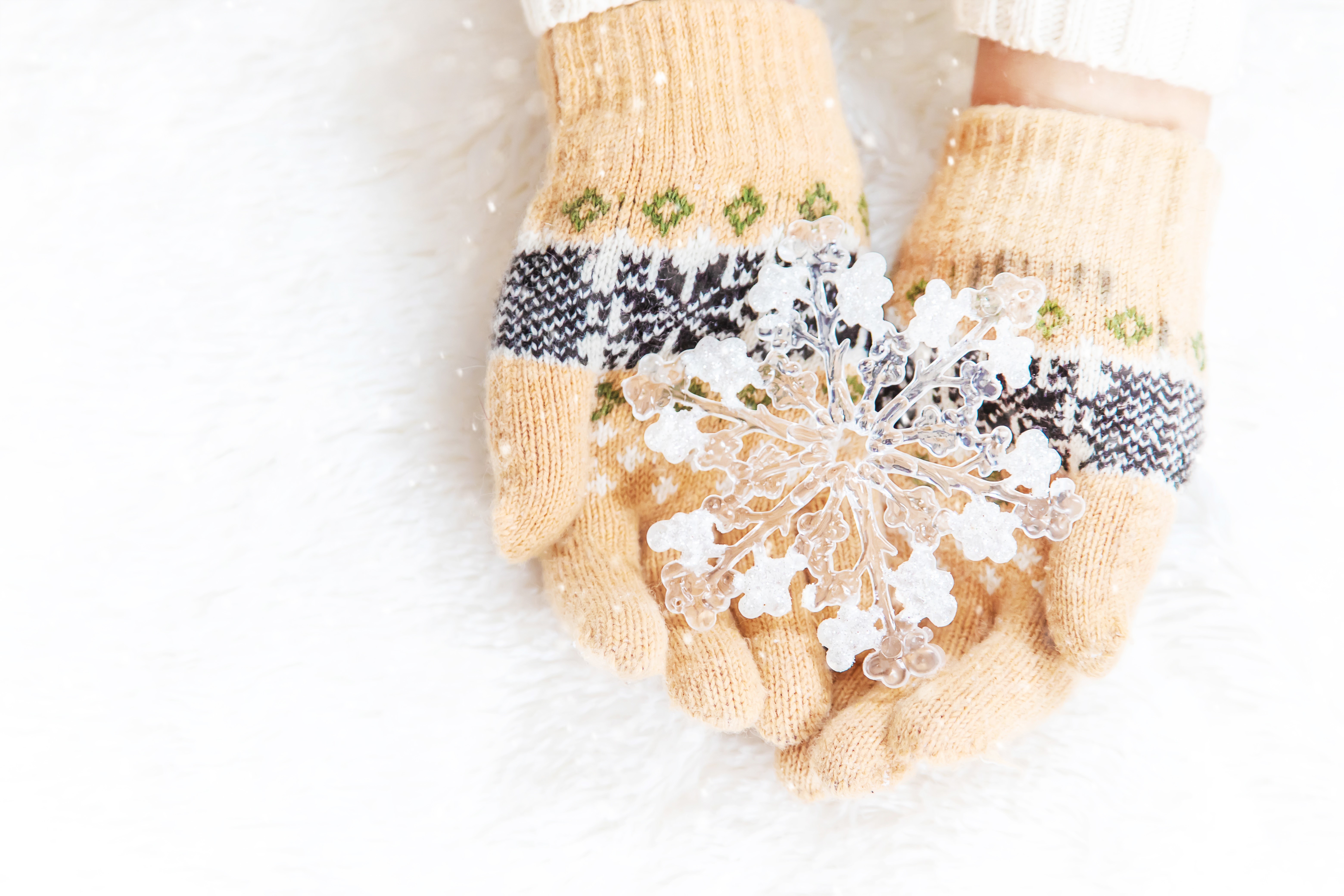 Hands in patterned gloves holding a snowflake HD Wallpaper