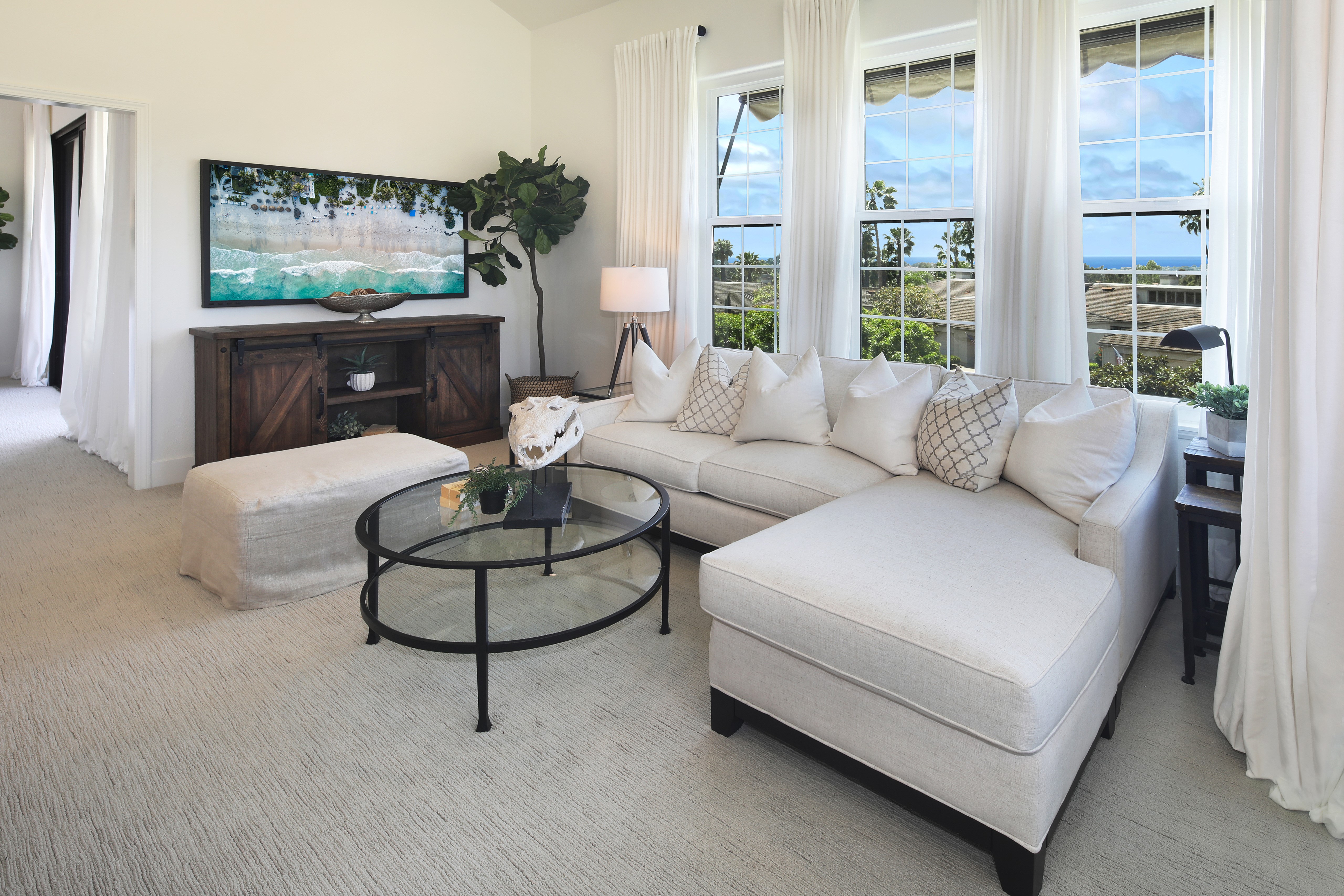 Living room with sofa, TV, and ocean view HD Wallpaper