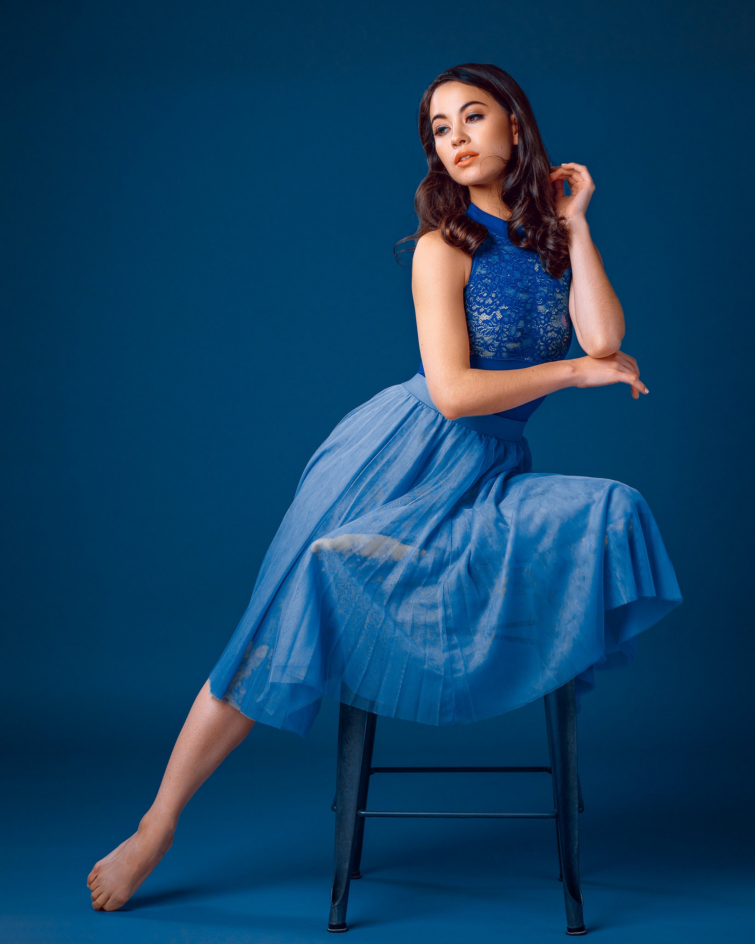 Maya sitting on a chair in a blue dress HD Phone Wallpaper