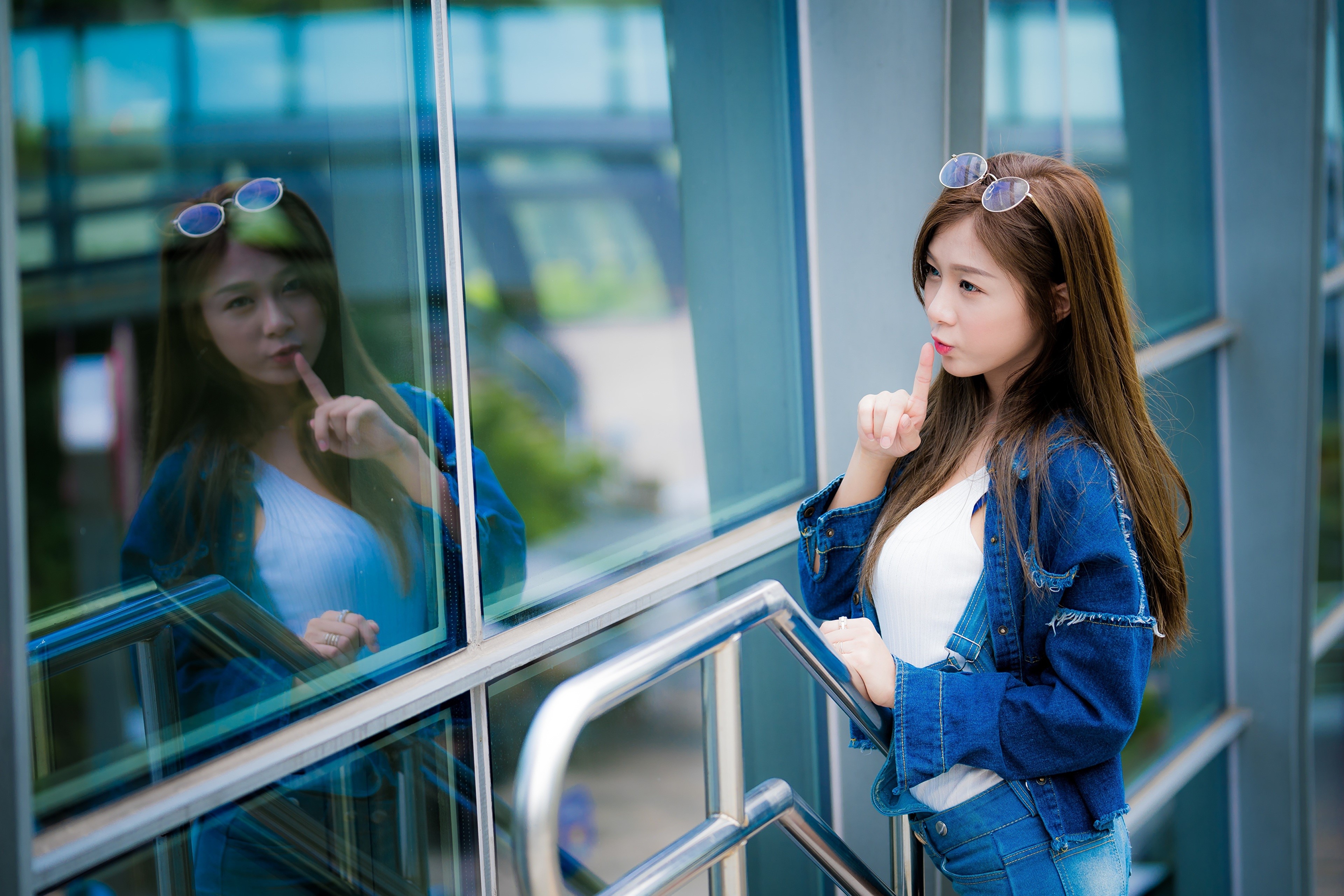 Asian woman with finger to lips in denim jacket HD Wallpaper