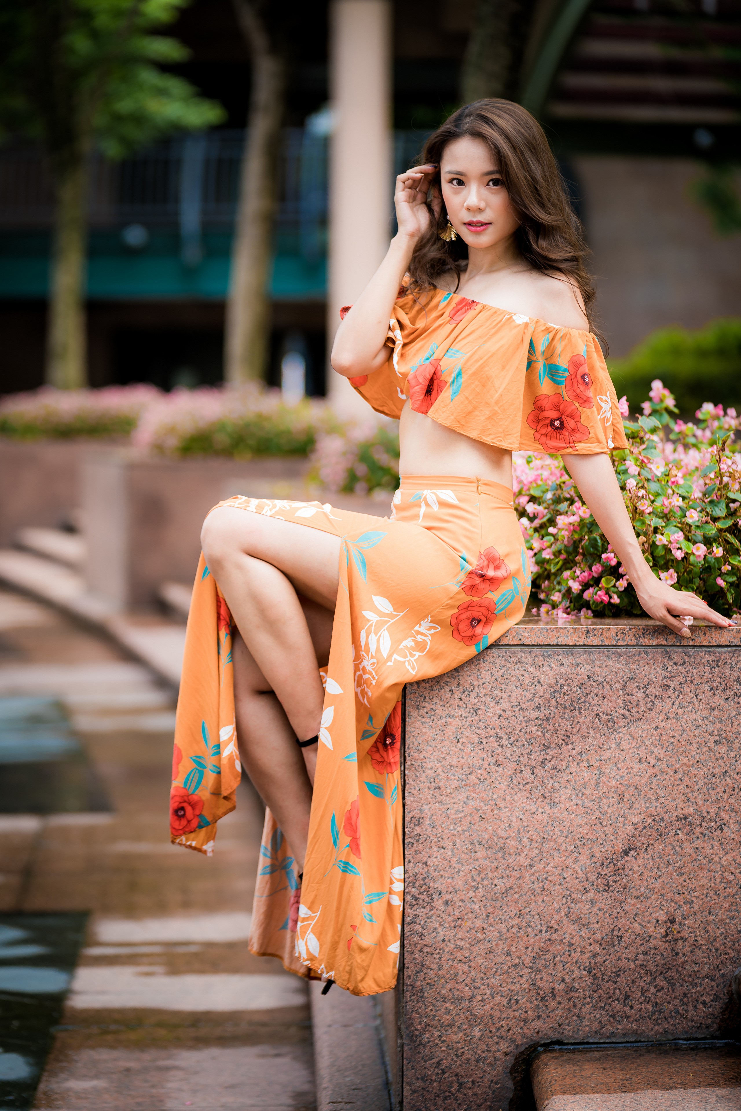 Asian woman in floral off-the-shoulder dress sitting outdoors HD Phone Wallpaper