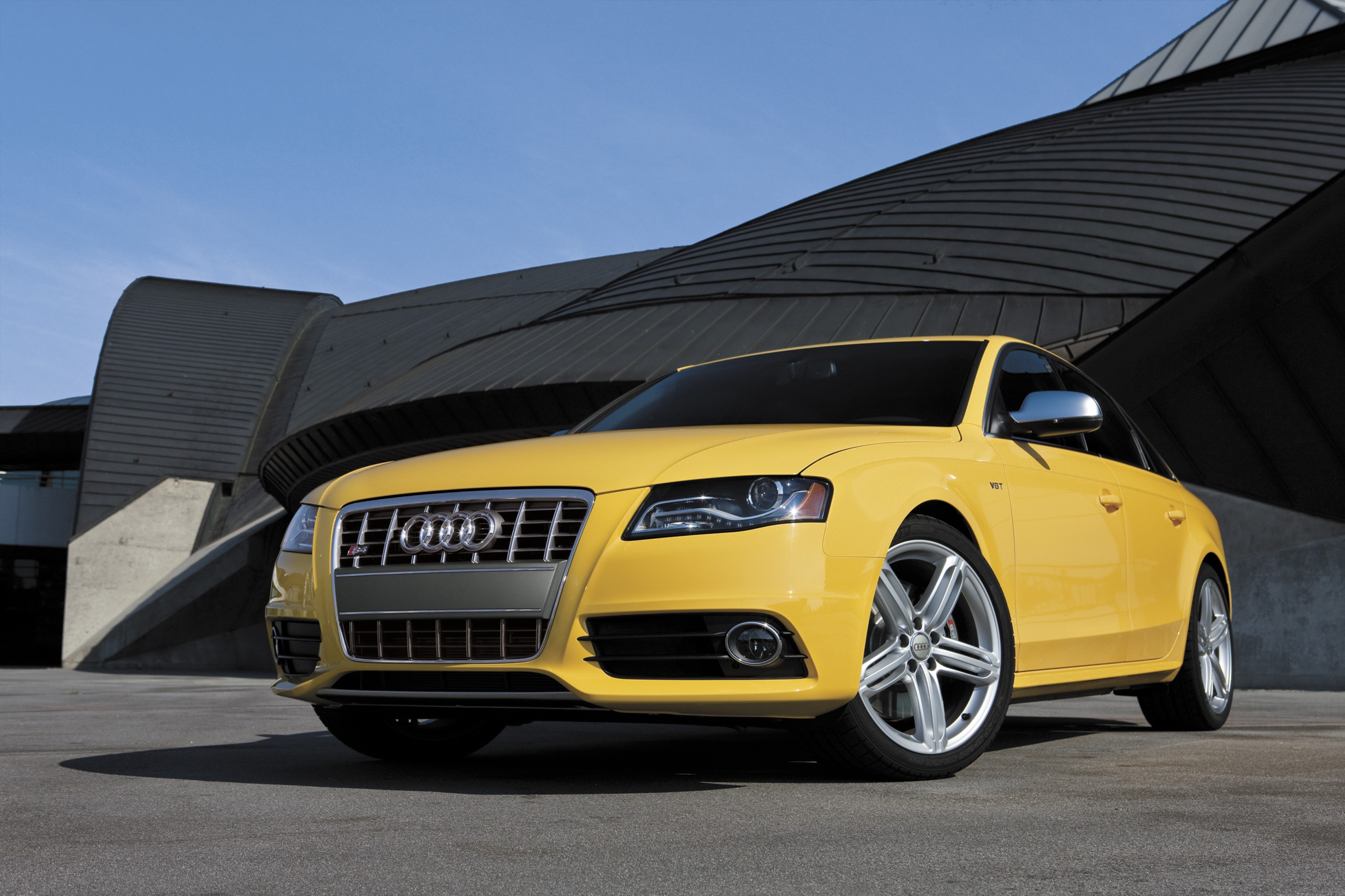 Yellow Audi S4 Sedan parked in front of modern architecture HD Wallpaper