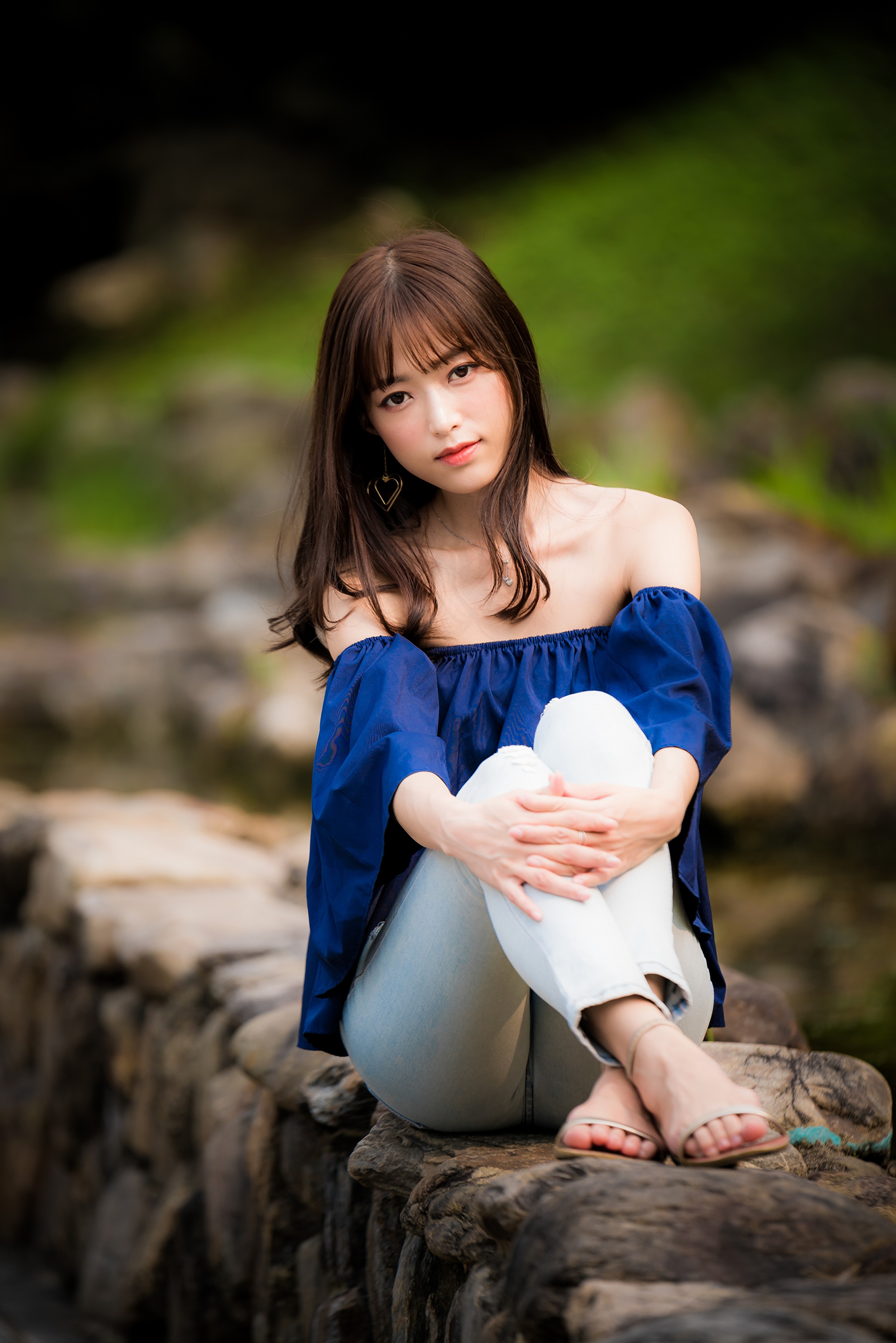 Asian Woman Sitting on Stone Wall with Bokeh HD Phone Wallpaper