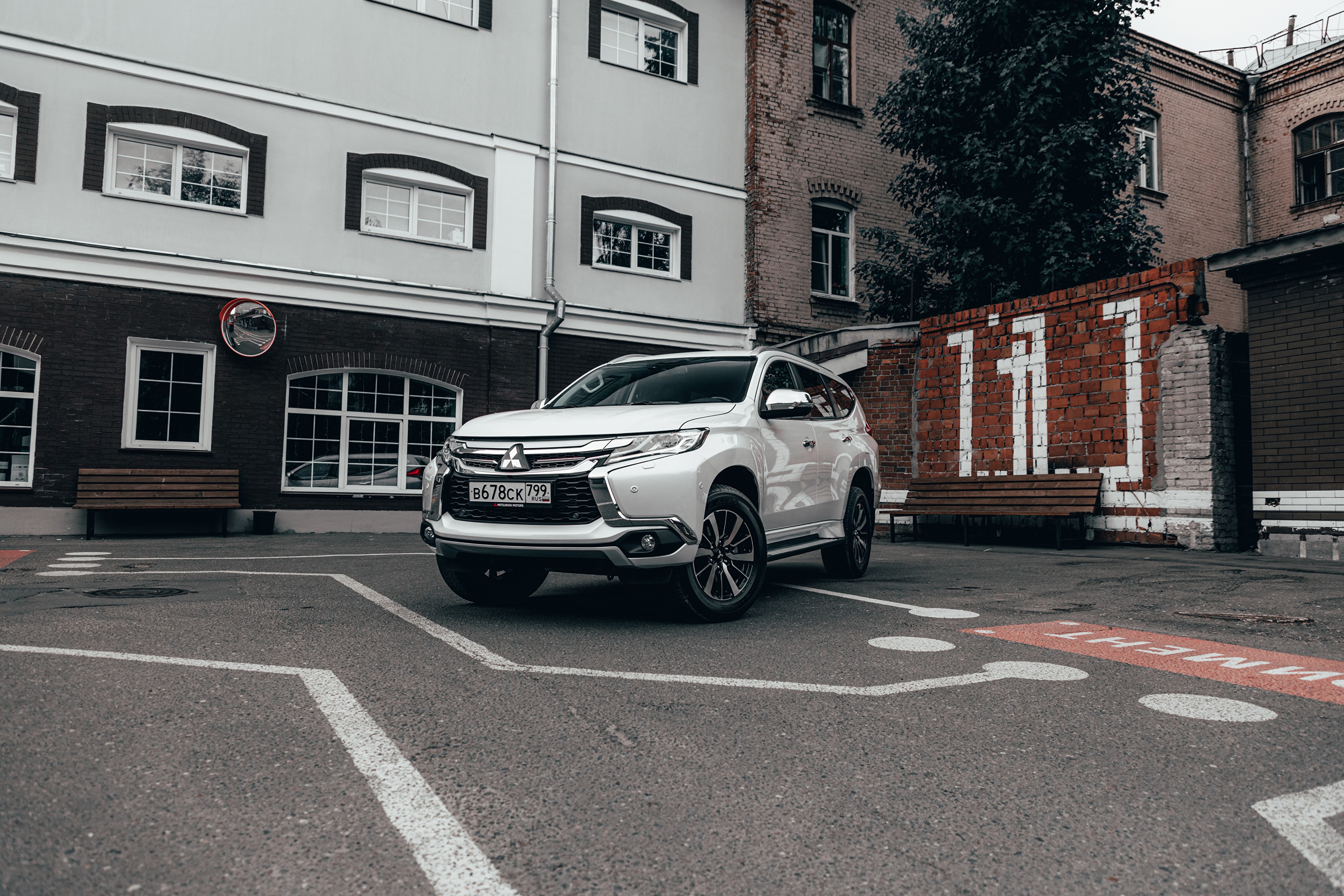 White Mitsubishi SUV parked in urban area HD Wallpaper