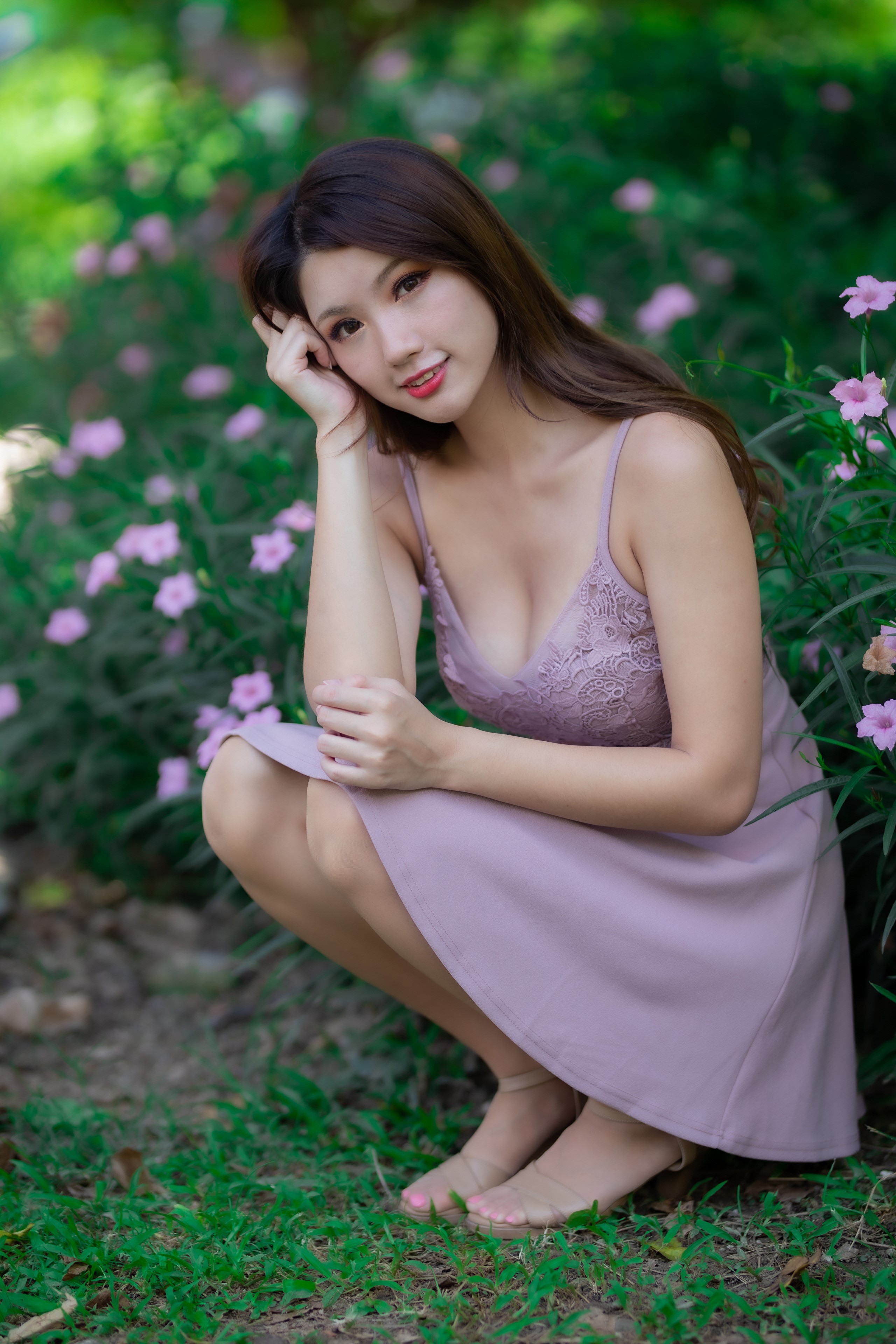 Asian woman in a purple dress crouching in a garden HD Phone Wallpaper